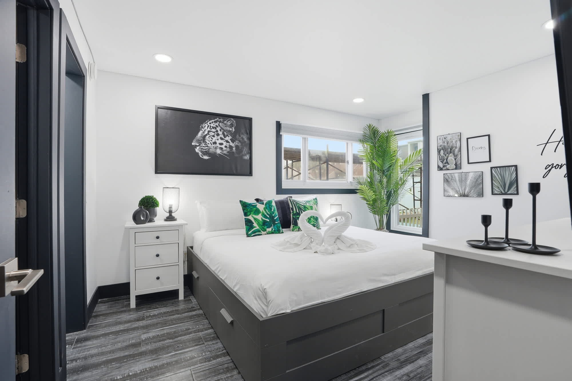 The Summit 132 – Cozy bedroom with a queen bed, decorative pillows, tropical accents, and a window view.