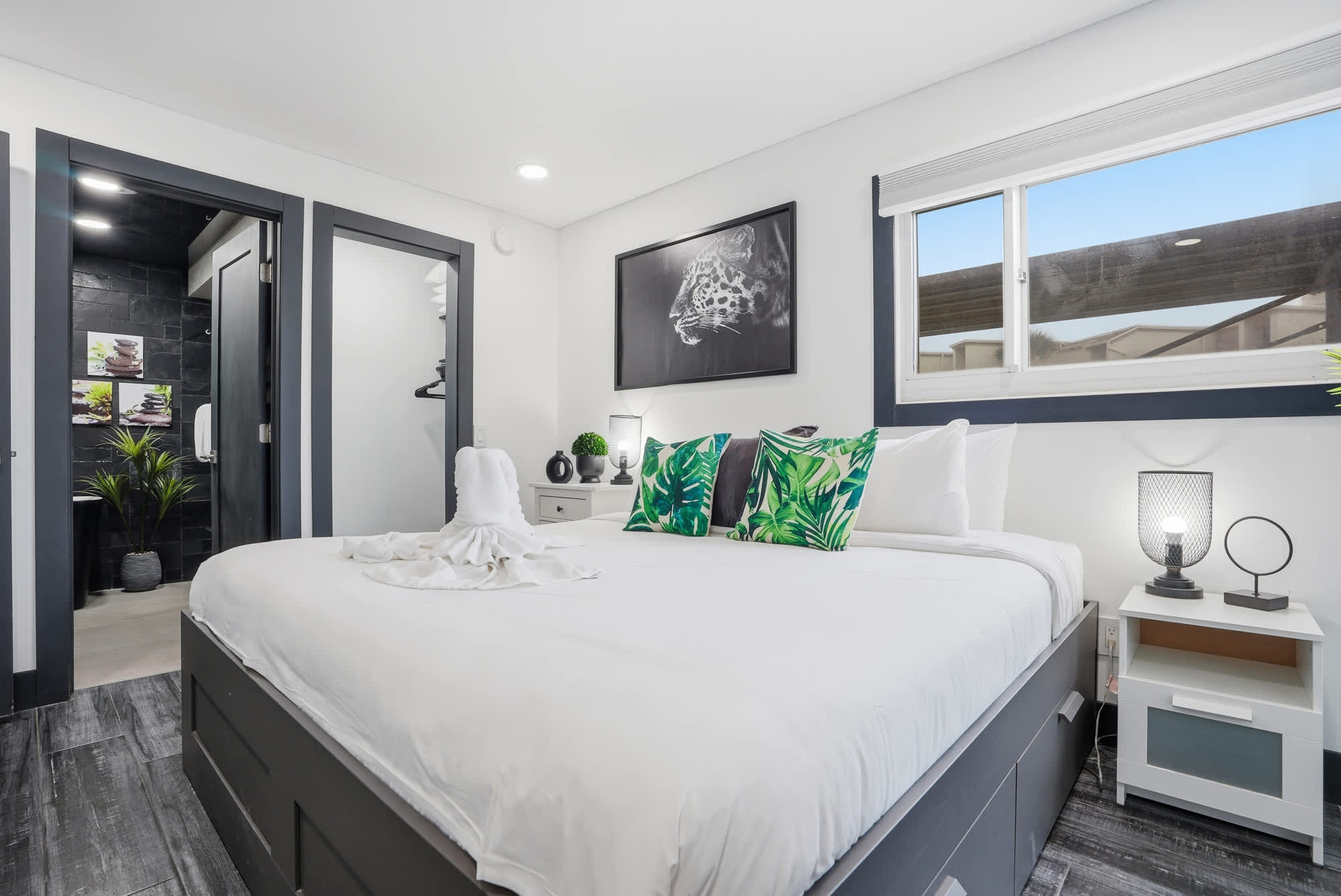 The Summit 132 – Cozy bedroom with a large bed, decorative pillows, and adjacent bathroom entrance.