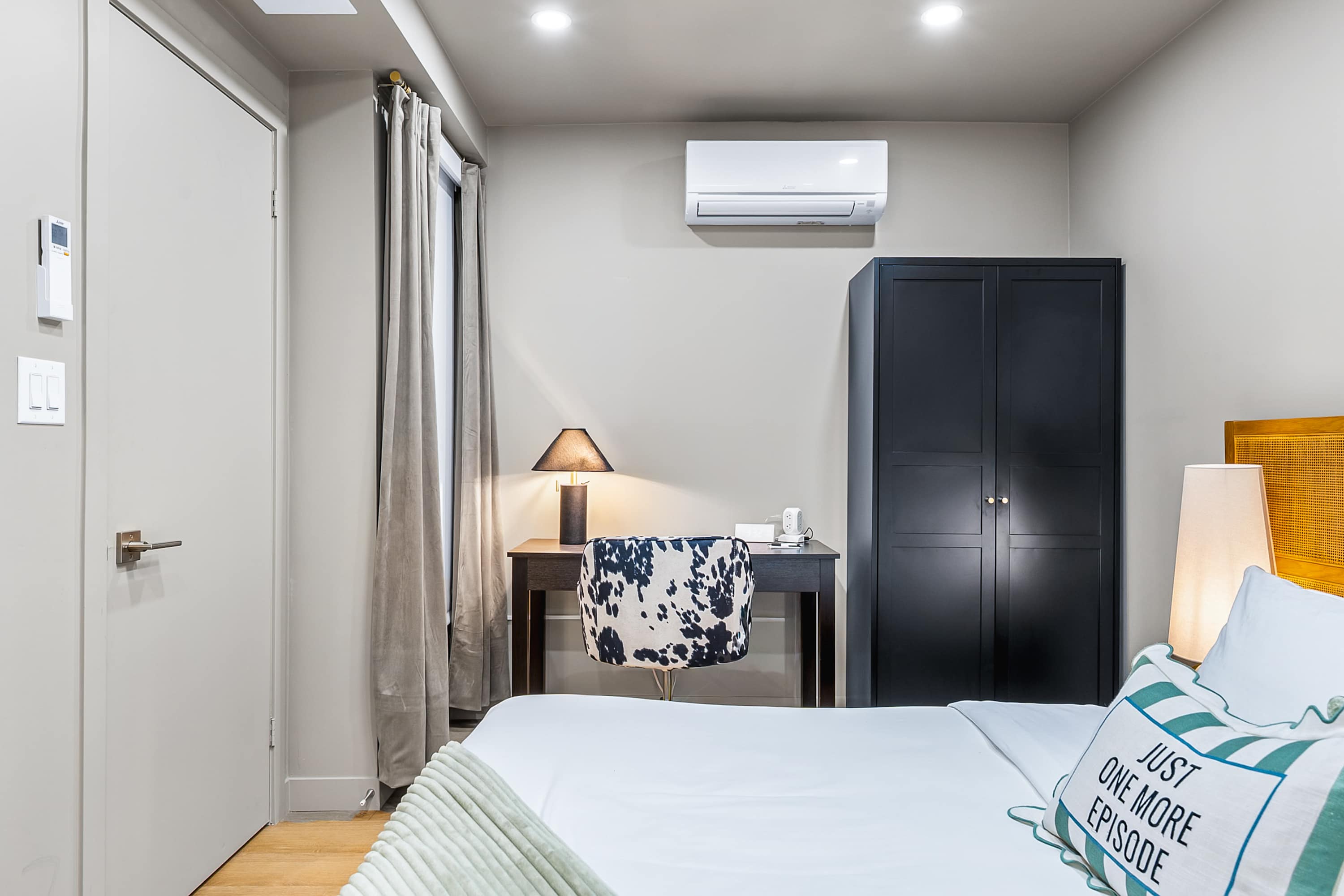 Comfortable bedroom with workspace and storage.