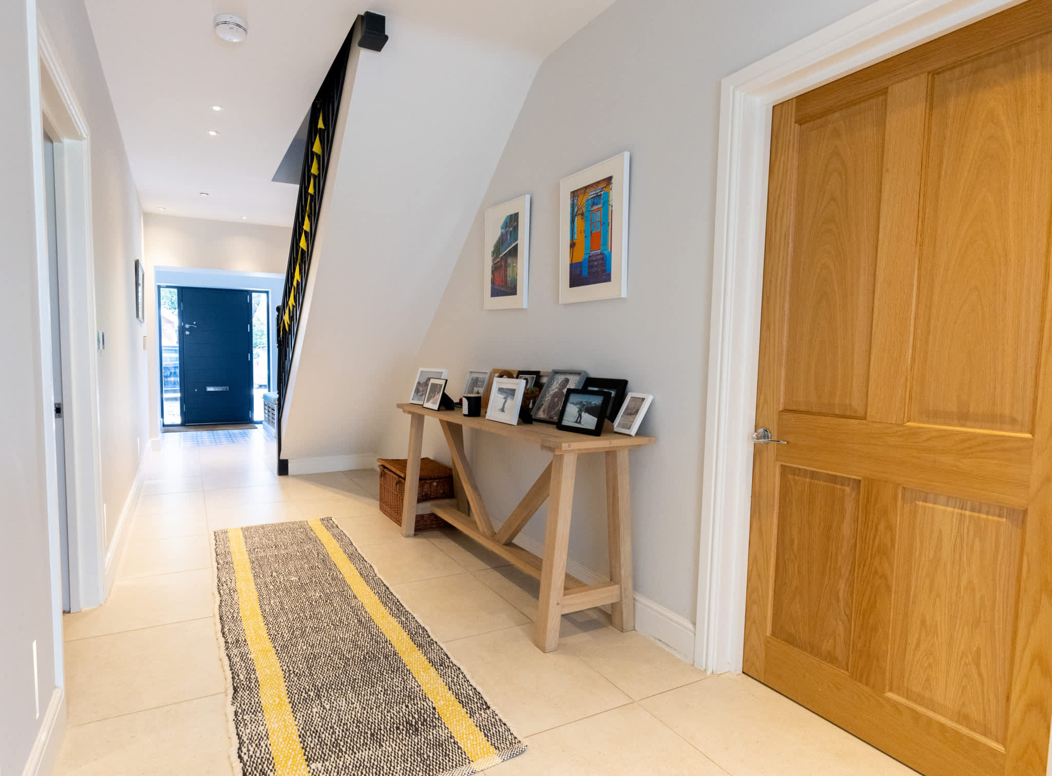 Light-filled hallway with wooden doors and a console table, offering a warm welcome to this spacious family home.