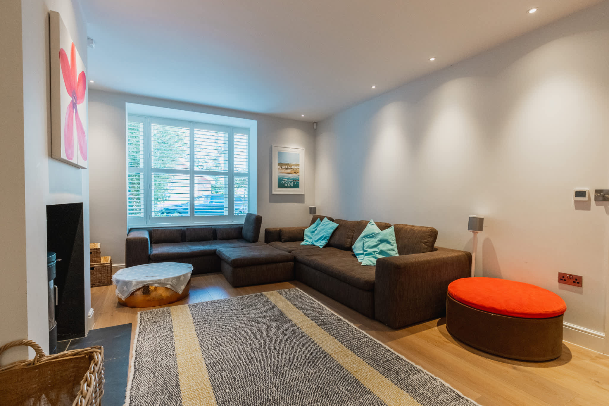 Cosy lounge with large sectional sofa, Smart TV and log burner—perfect for relaxing after a day exploring Chichester.