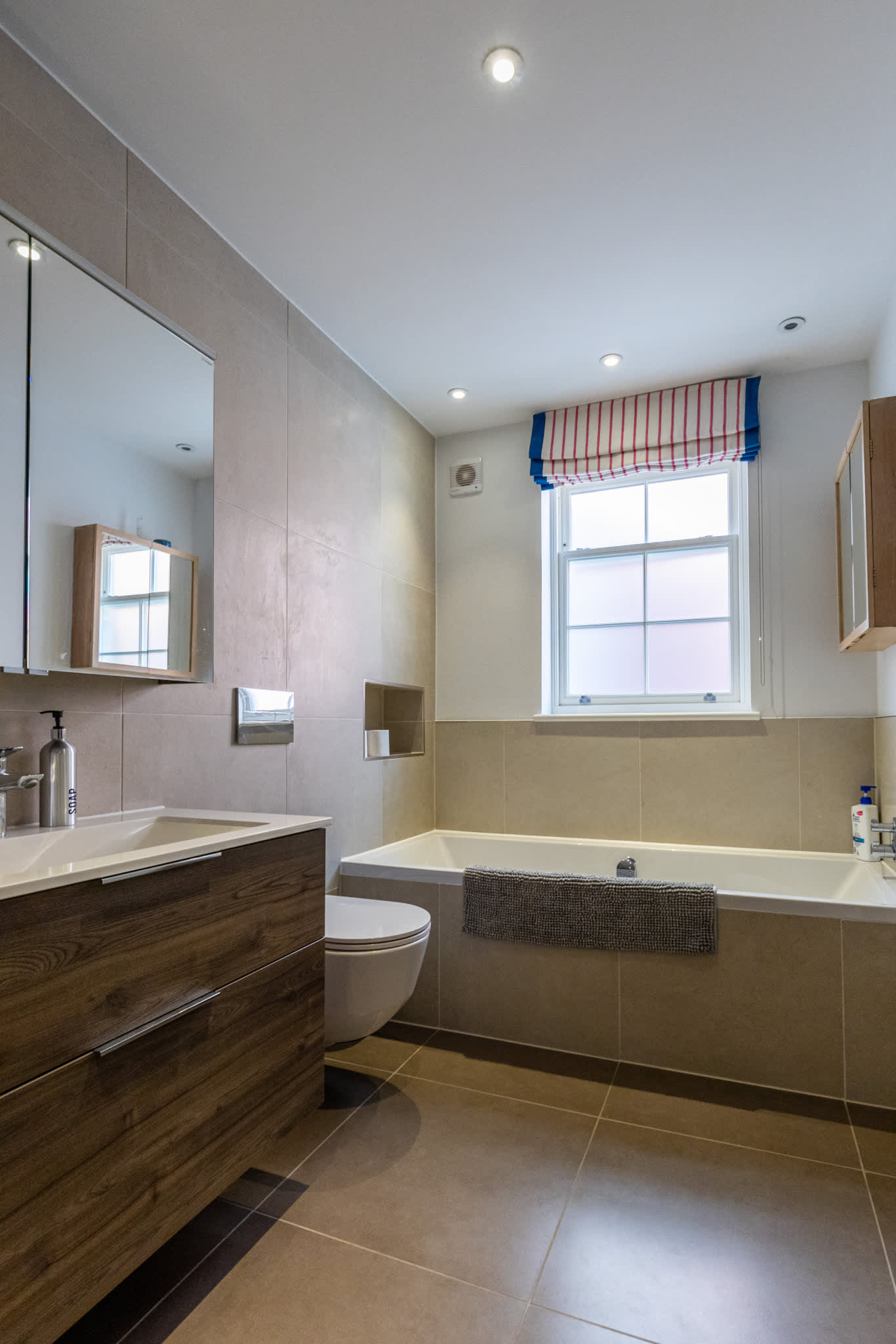 Modern bathroom with bathtub, sleek vanity and contemporary finishes for a relaxing stay.