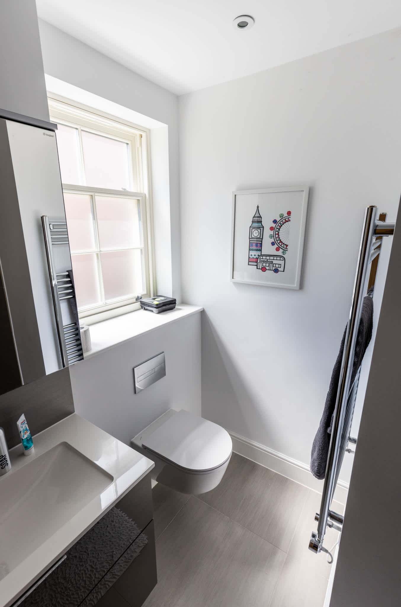 Modern ensuite bathroom with sleek fittings, WC, sink and heated towel rail.