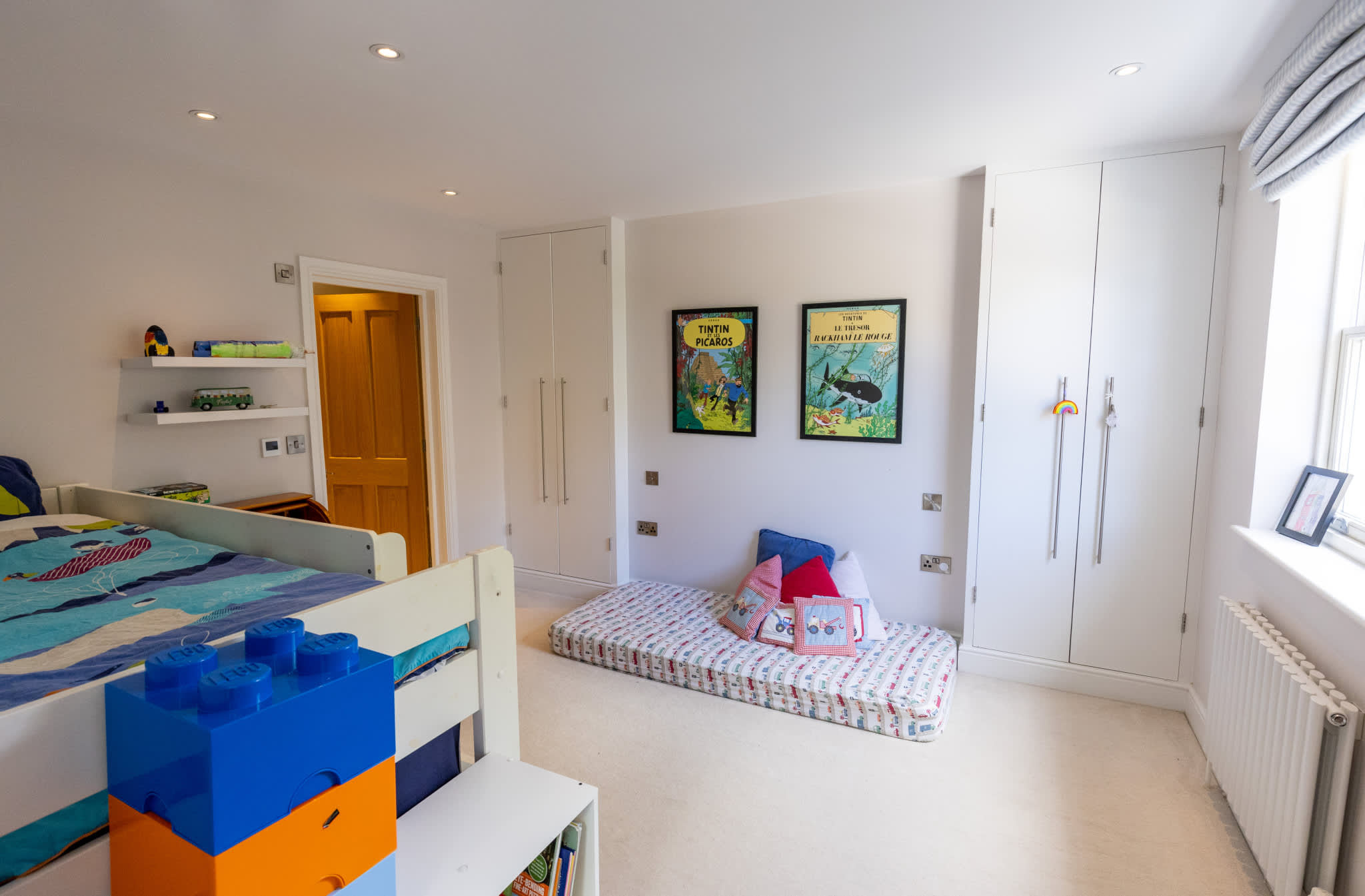 Bright kids’ bedroom with bunk bed, built-in wardrobes and cosy reading nook.