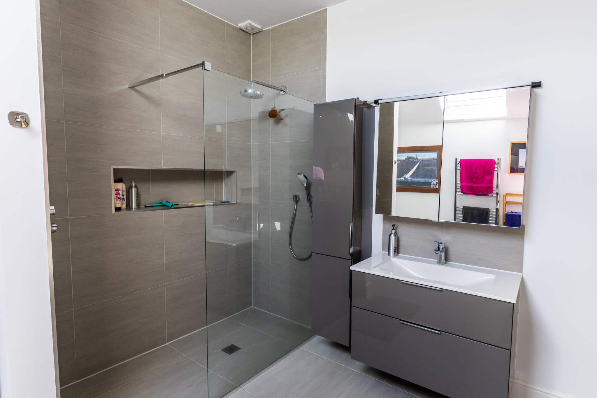 Modern bathroom with walk-in glass shower, sleek vanity and contemporary finishes.