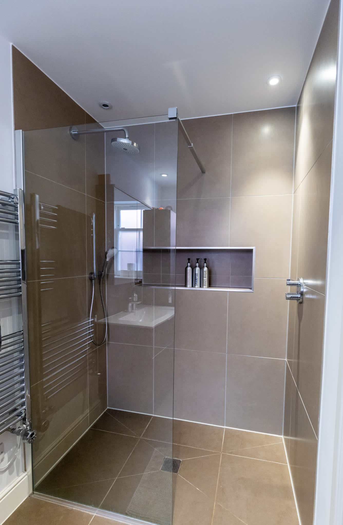 Modern tiled shower room with glass enclosure and stylish fittings.