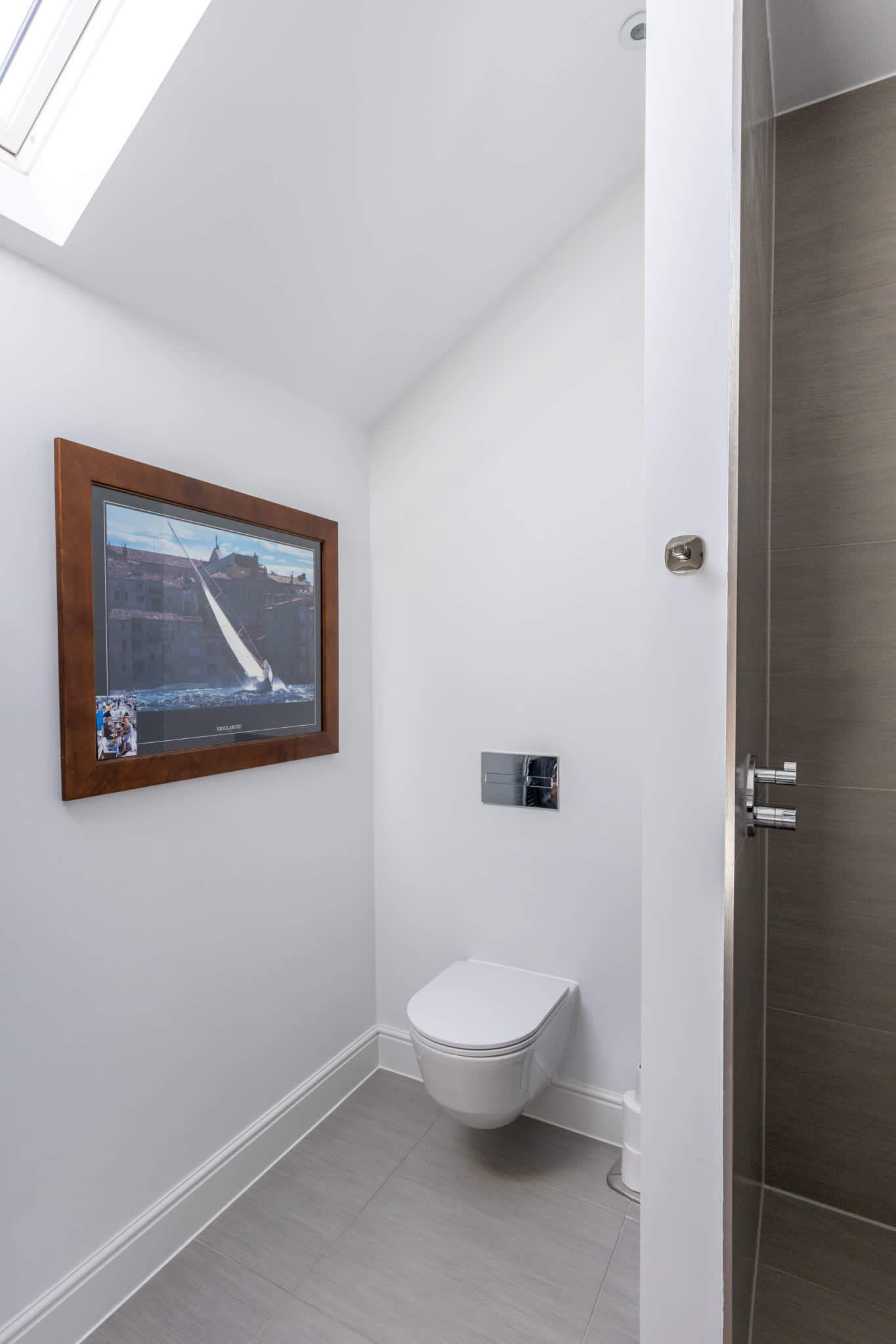 Stylish WC with skylight and modern fittings, adding convenience to the upper floor.