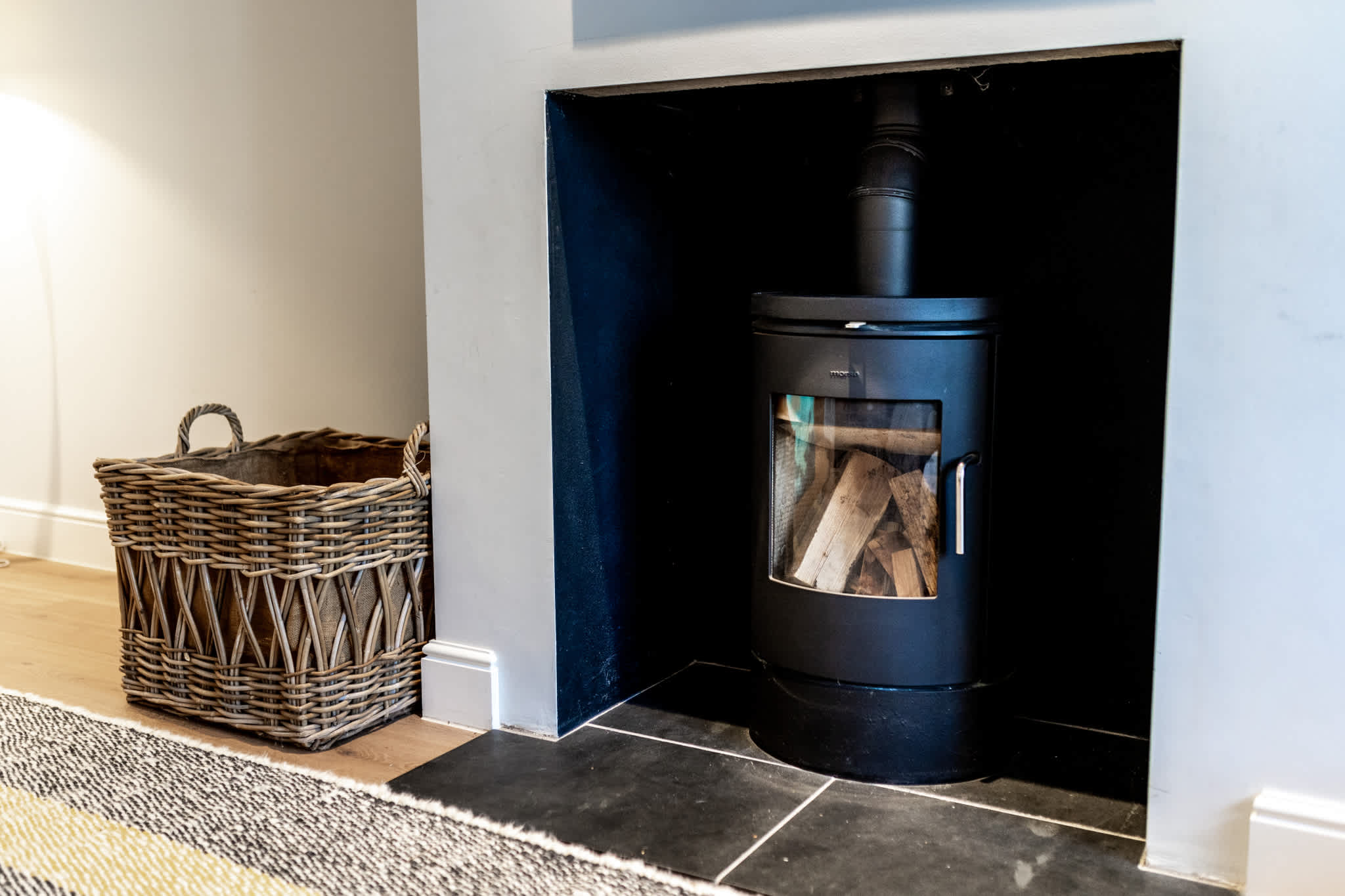 Modern wood-burning stove set in a sleek fireplace, perfect for cosy evenings after exploring Chichester.