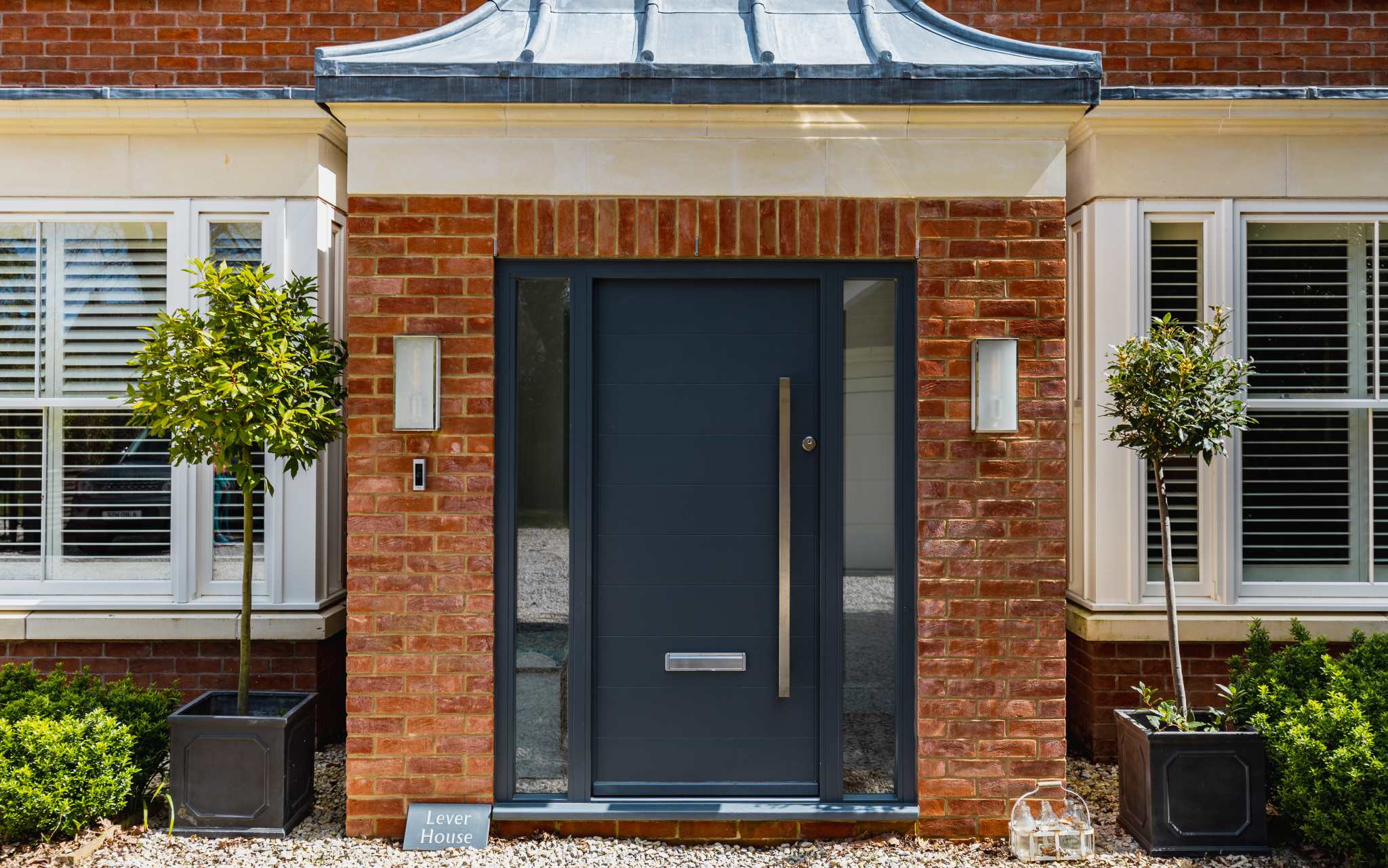 Elegant front entrance with modern door and landscaped details, creating a stylish first impression.