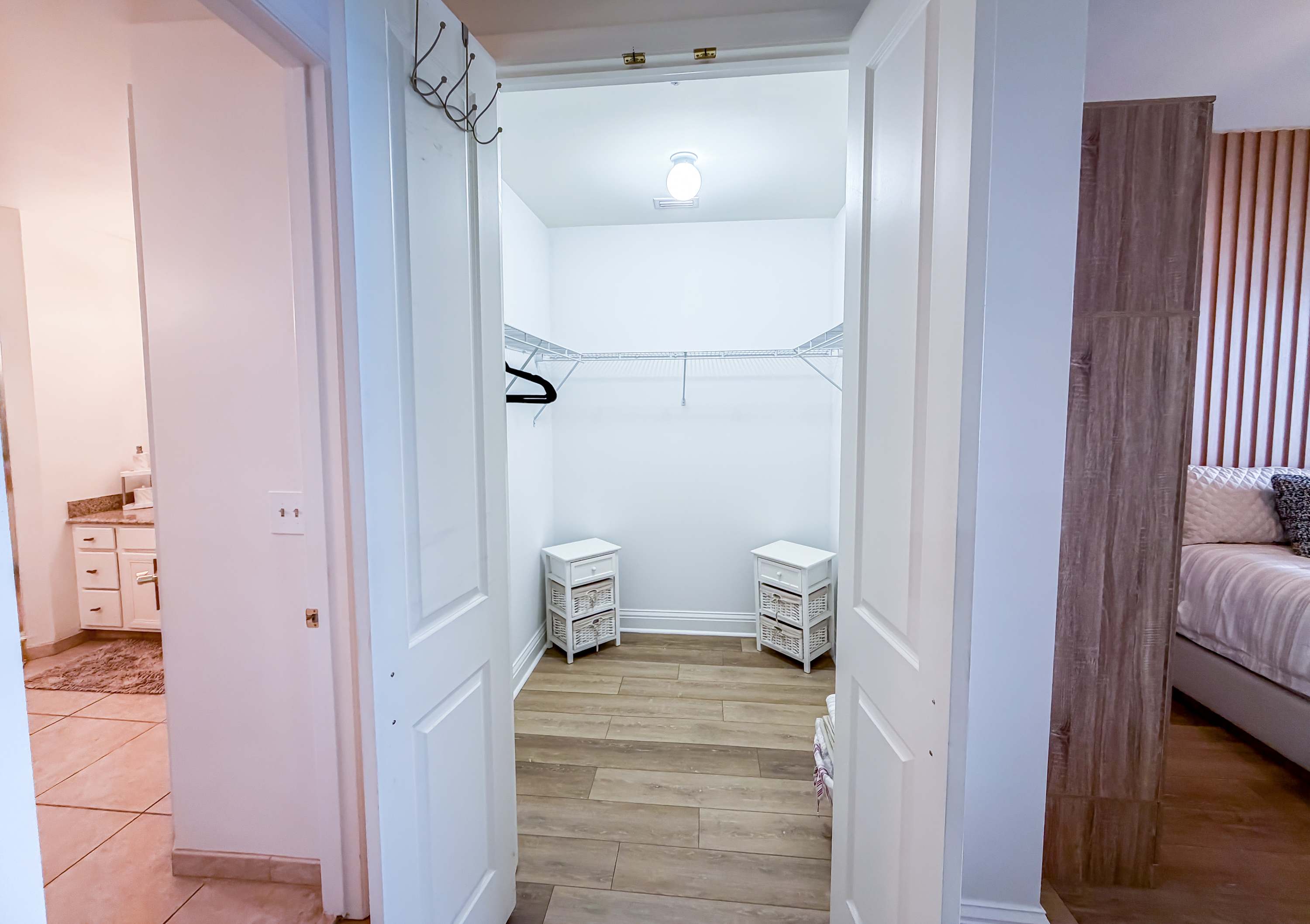Marriott 3707 – Walk-in closet with shelving, hooks, and white storage units; adjacent room visible through open door.