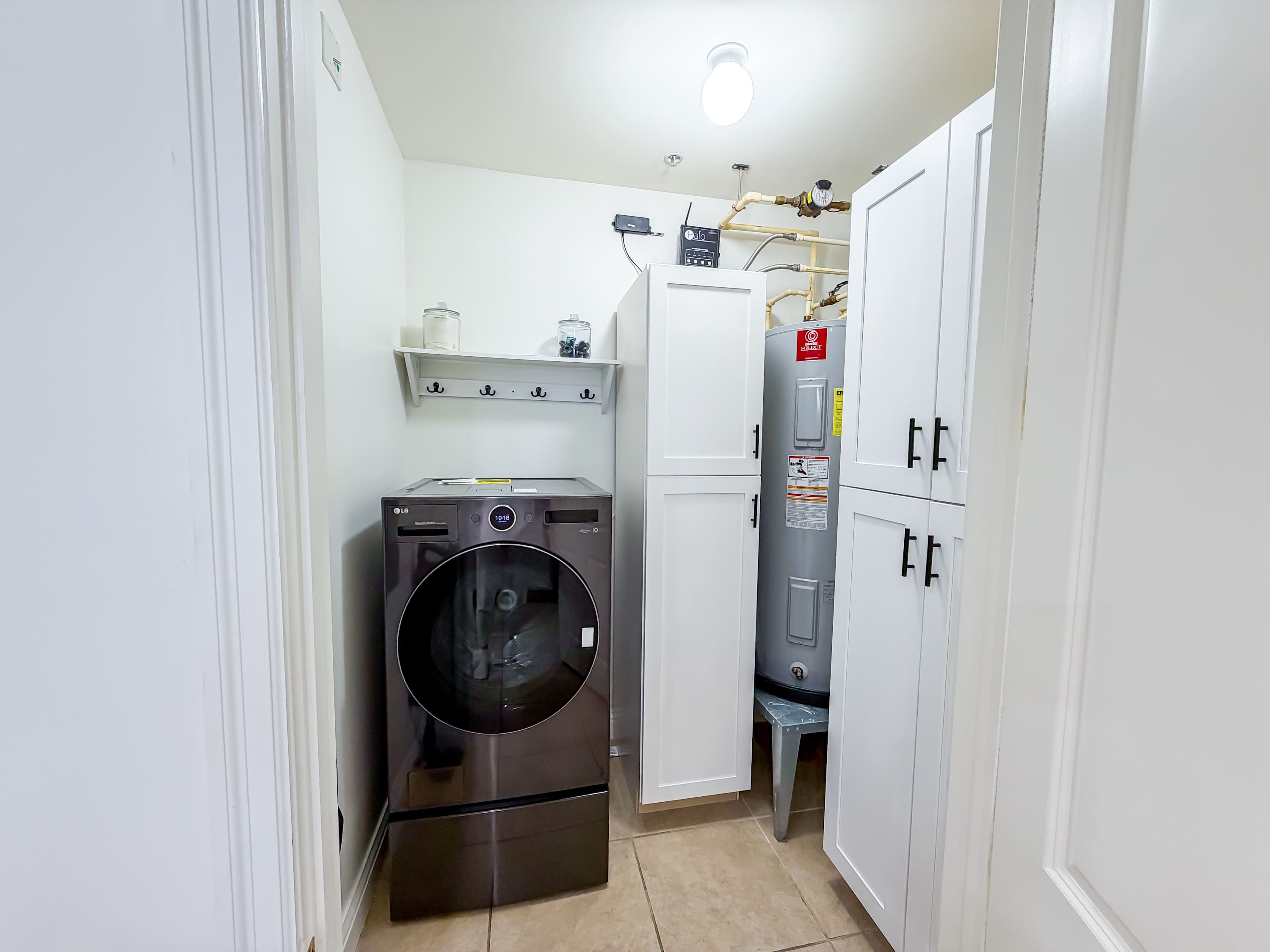 Marriott 3707 – Laundry area with a washing machine, shelves, and a water heater behind closed cabinets.