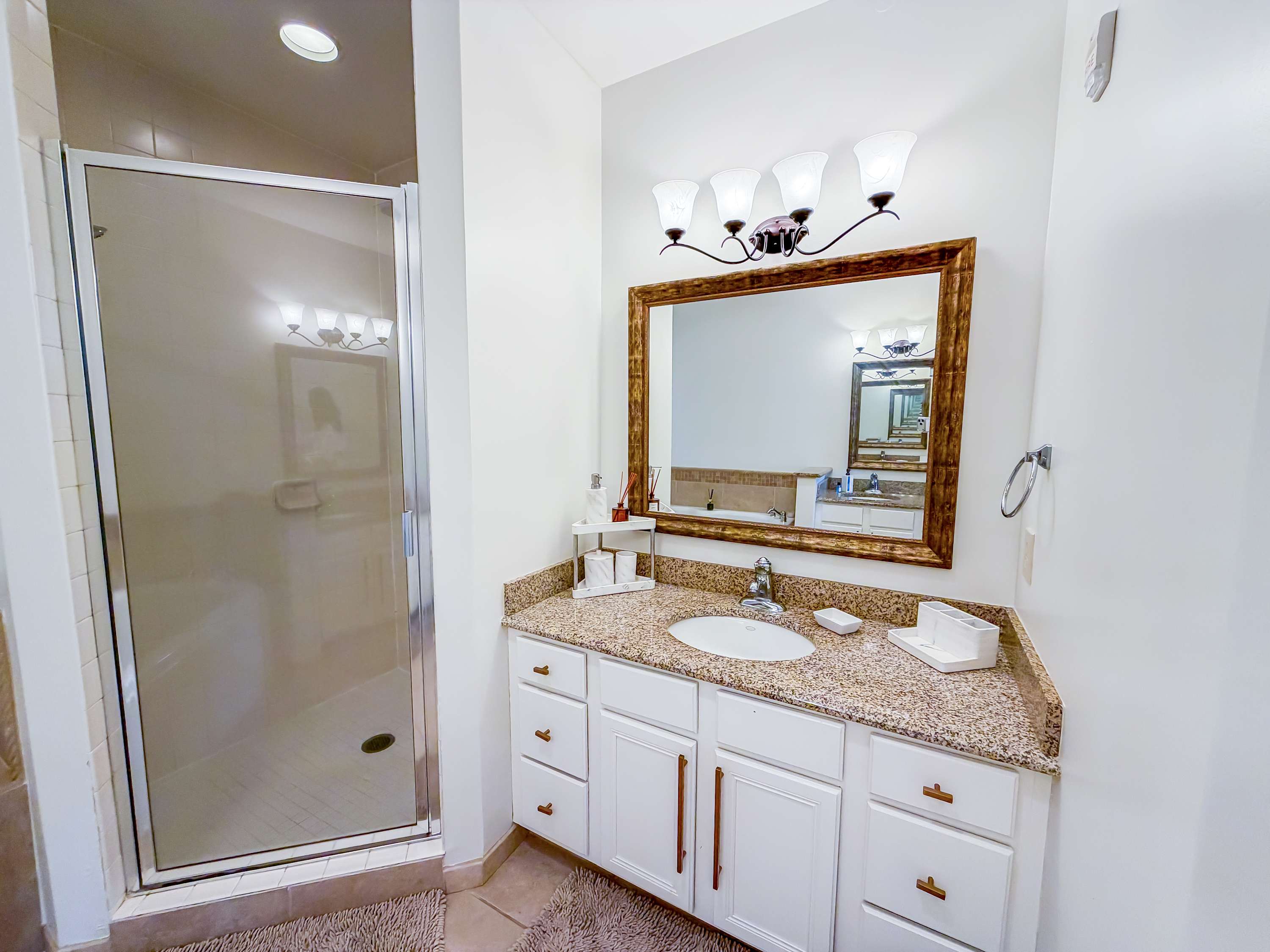 Marriott 3707 – Bathroom with a walk-in shower, granite countertop, and a large mirror above the sink.
