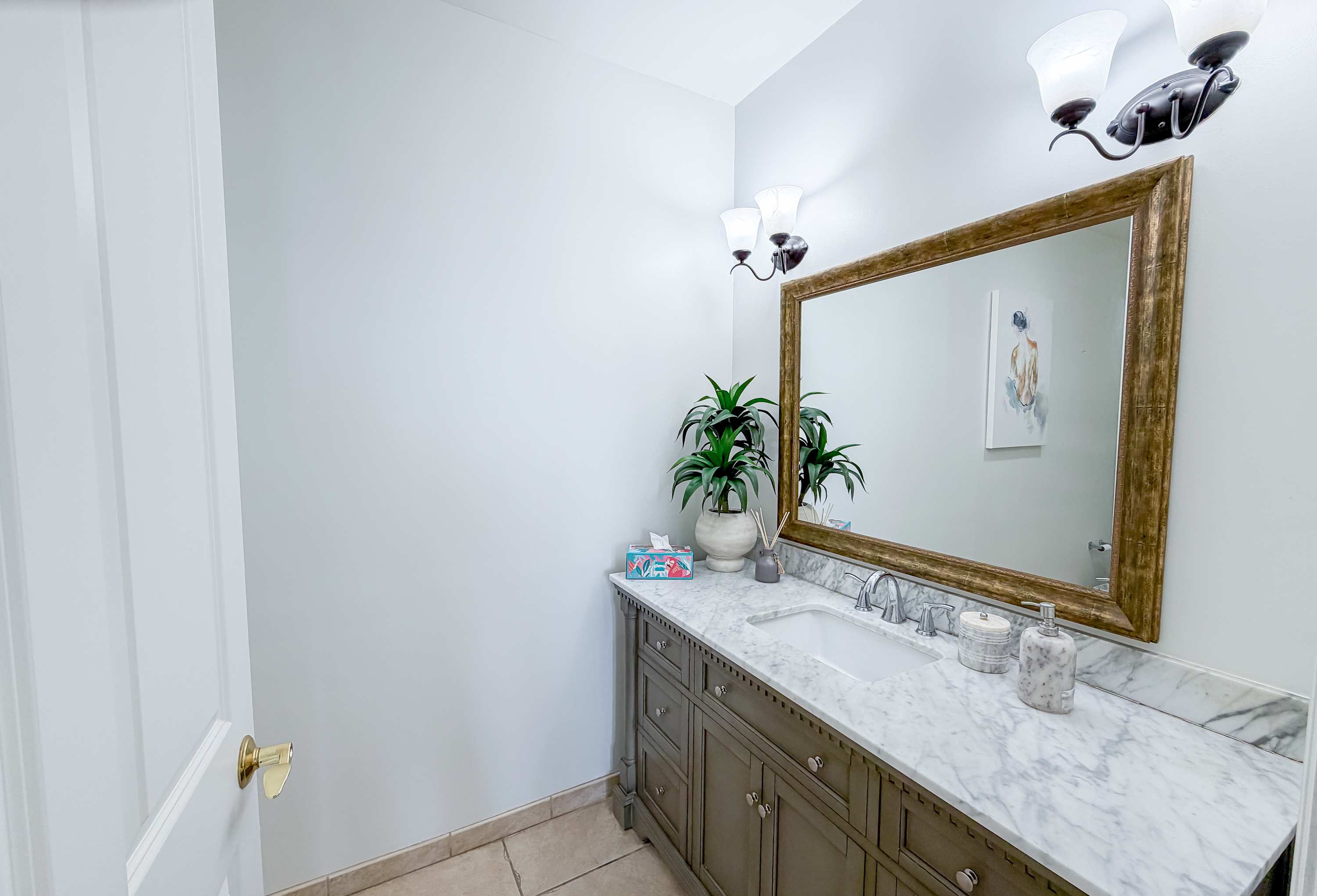 Marriott 3707 – Bathroom with marble countertop, large mirror, decorative plants, and soft lighting fixtures.