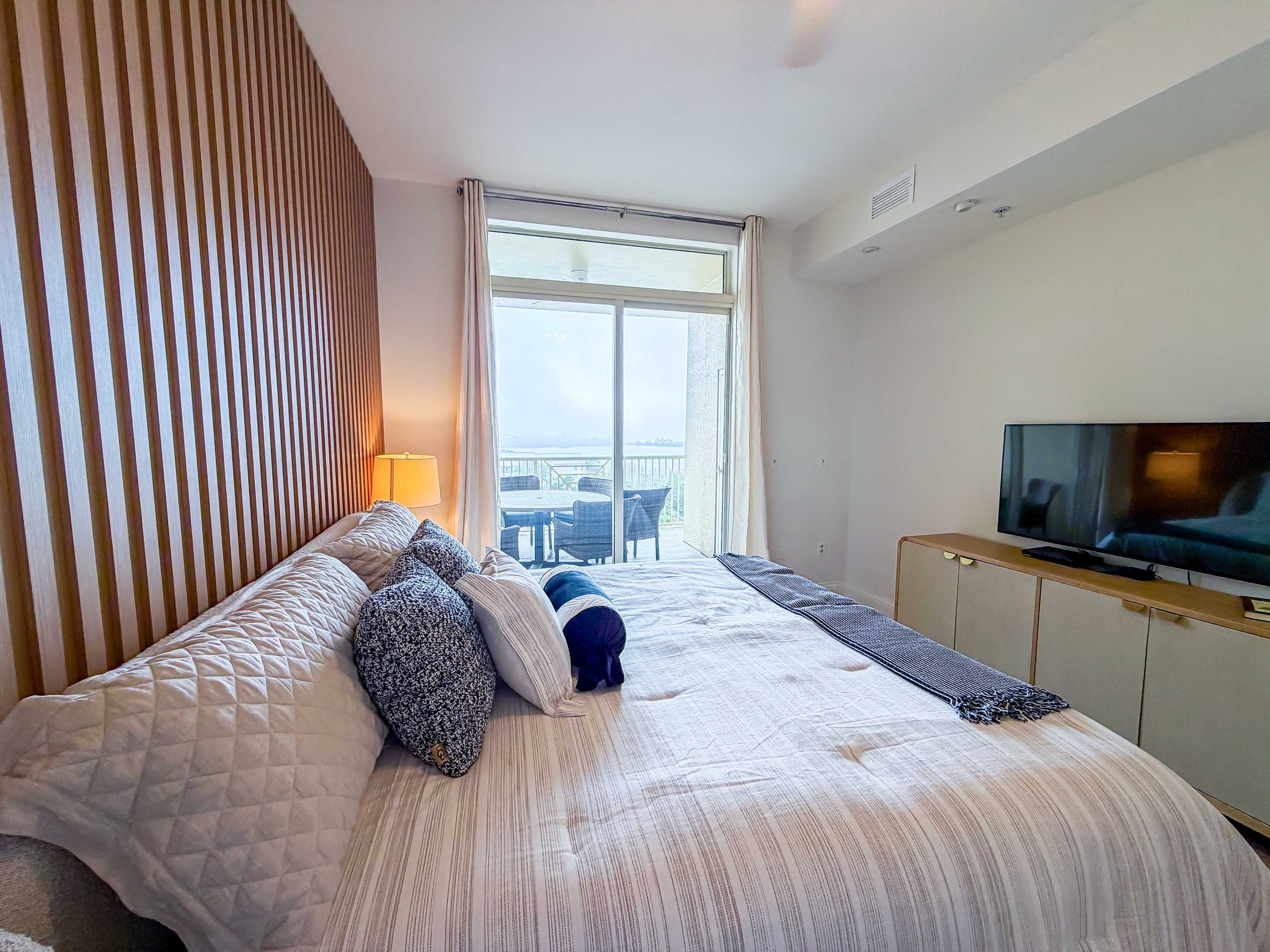 Marriott 3707 – Bedroom with a large bed, television, and a view of a balcony.