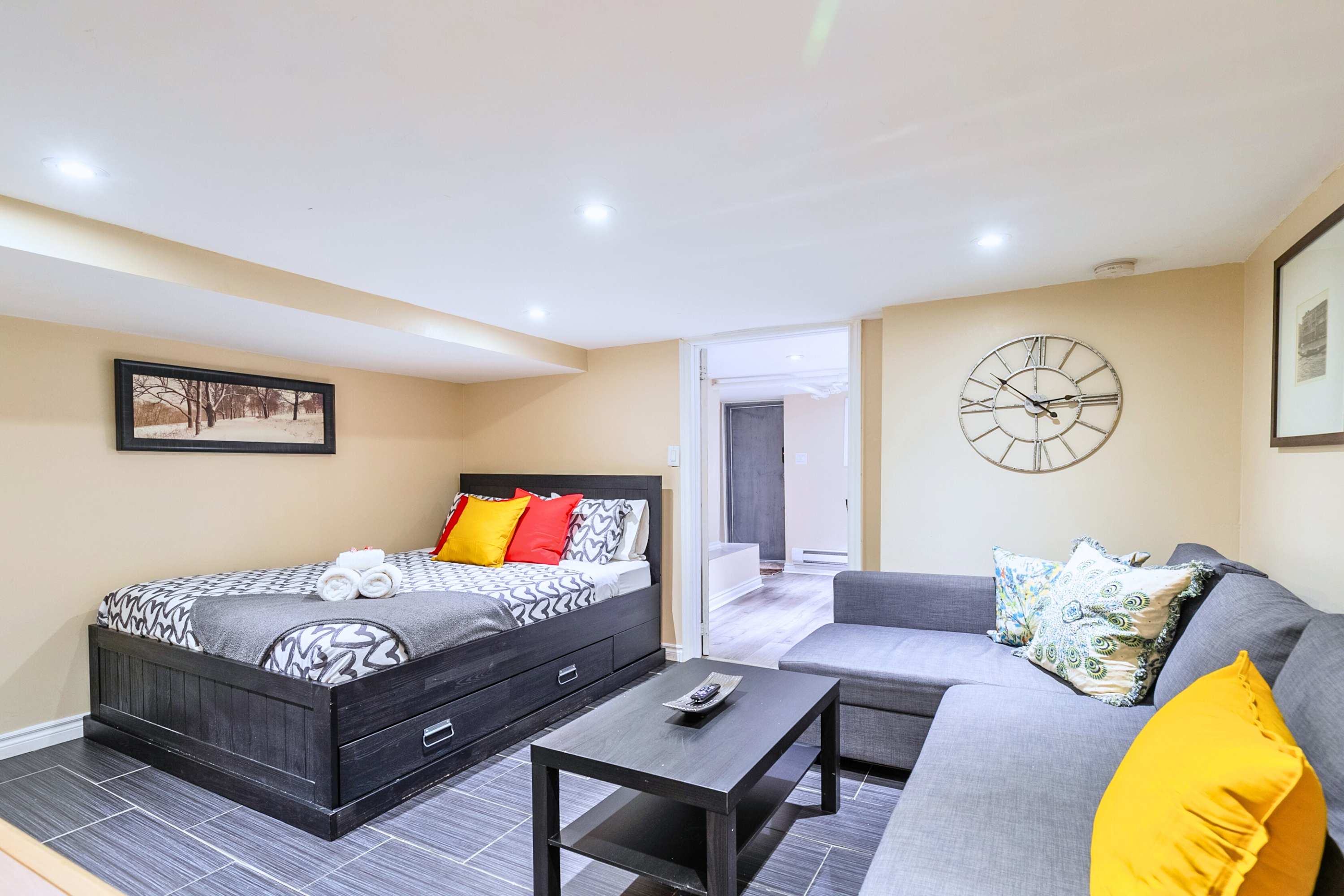 Comfortable queen bed with sofa bed and center table, ideal for relaxing or accommodating extra guests.