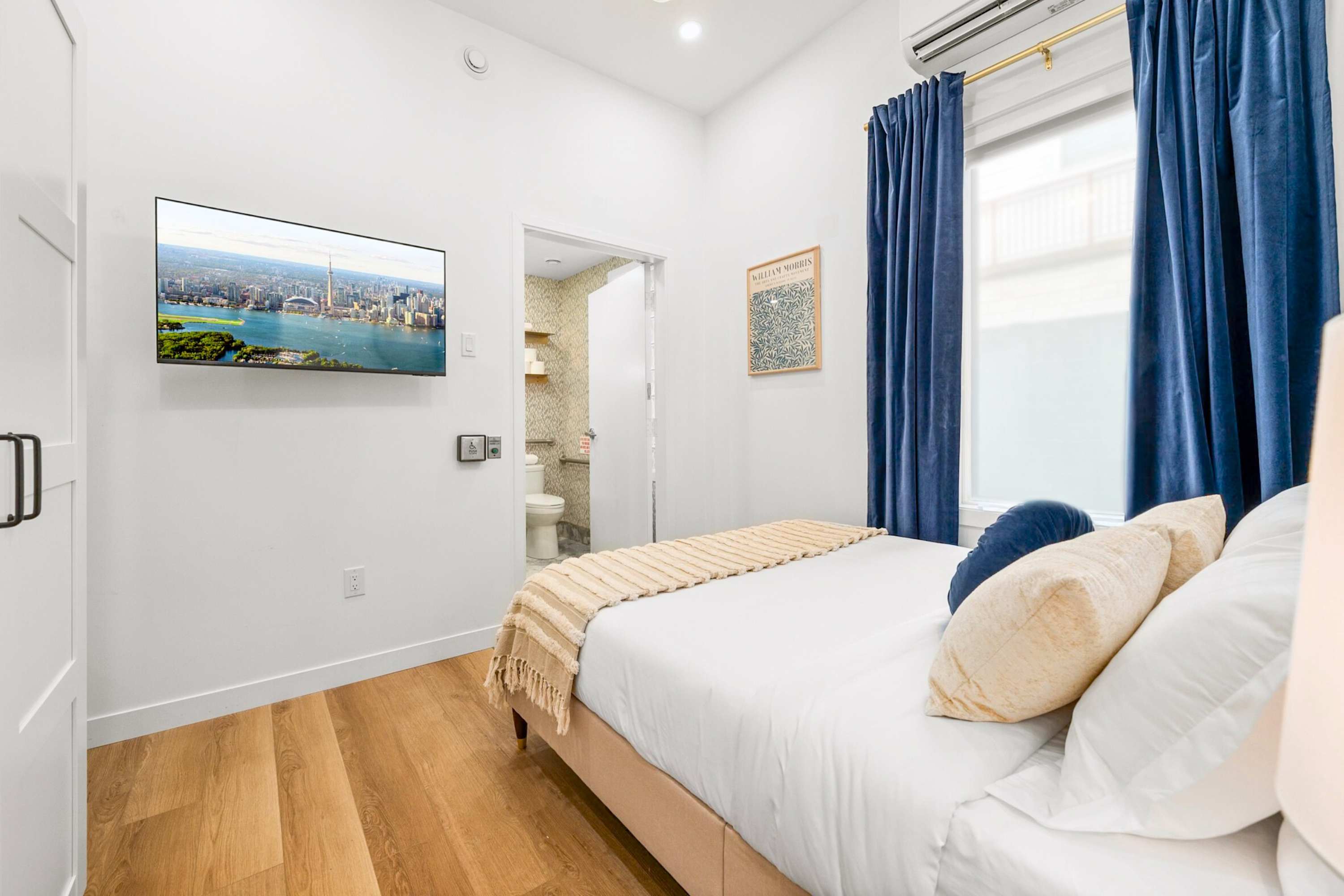 Serene bedroom with a plush queen bed and a smart TV.