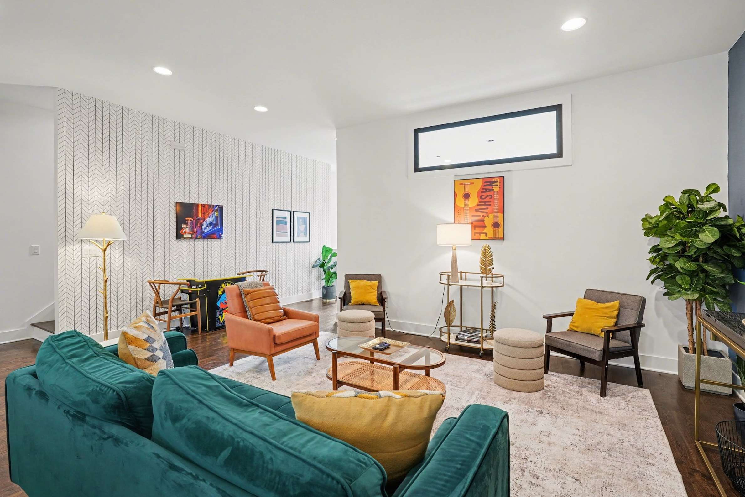 Open-concept living room with plush seating, large windows, and a chef's kitchen.