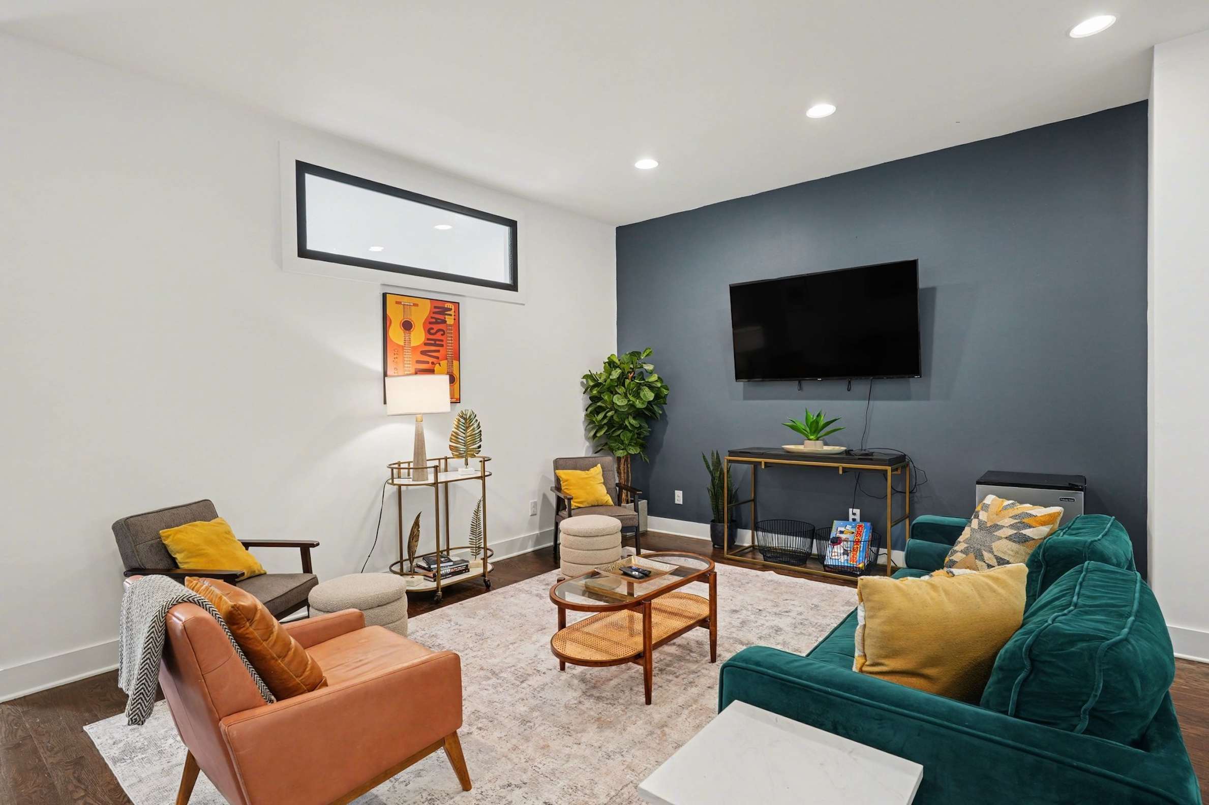 Open-concept living room with plush seating, large windows, and a chef's kitchen.