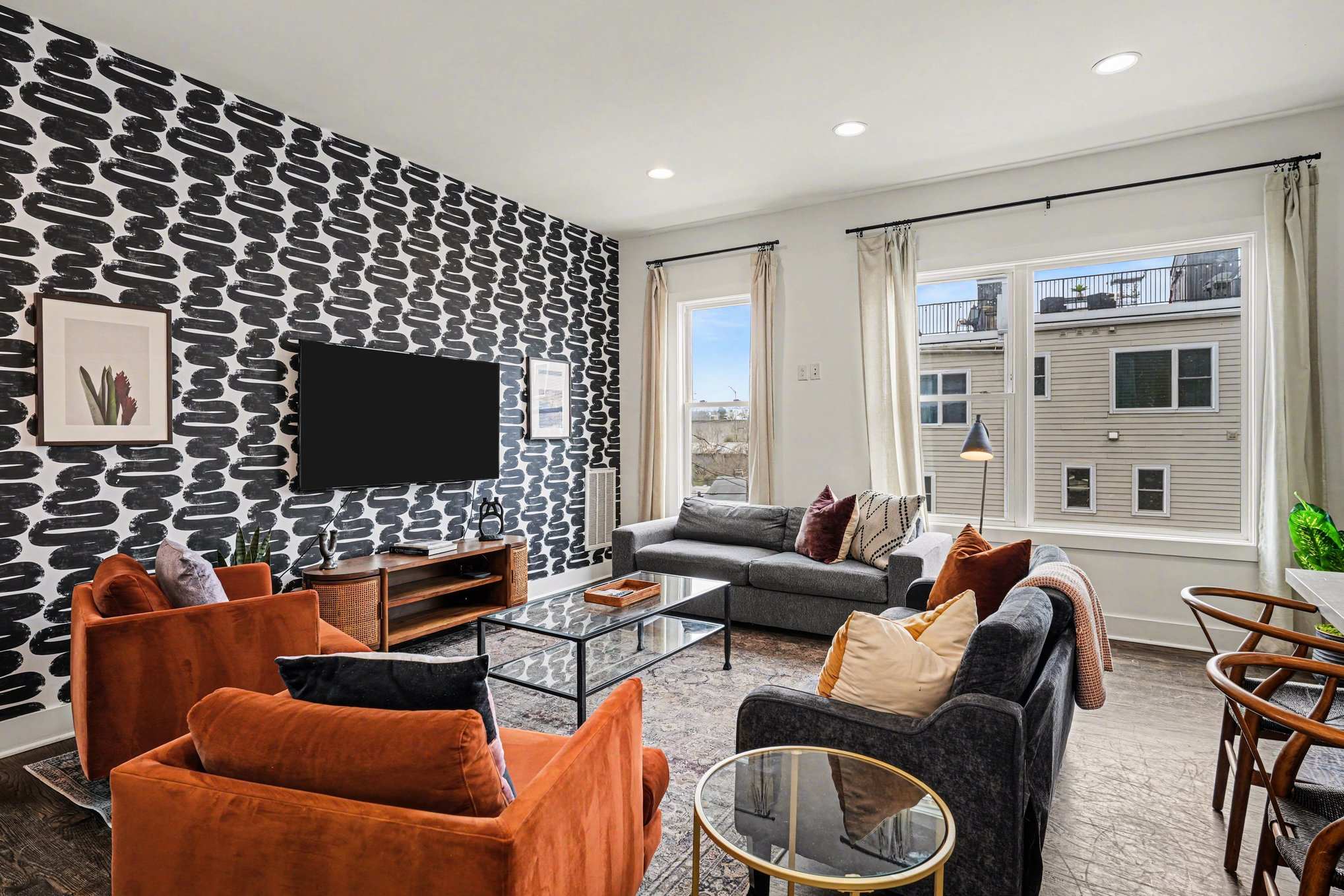 Open-concept living with foosball table, plush seating, and a bright, modern kitchen. | Unit A