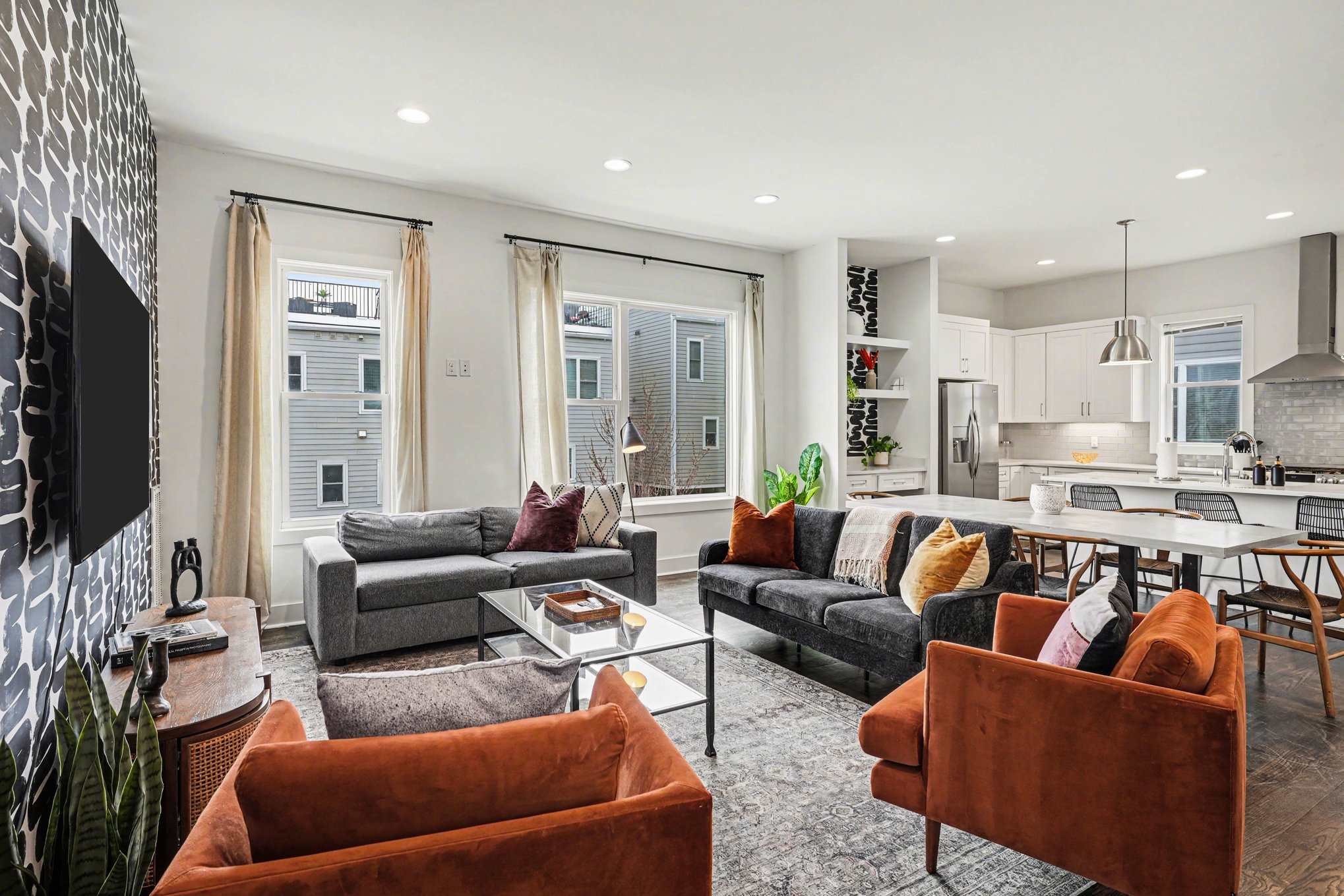 Open-concept living with foosball table, plush seating, and a bright, modern kitchen. | Unit A