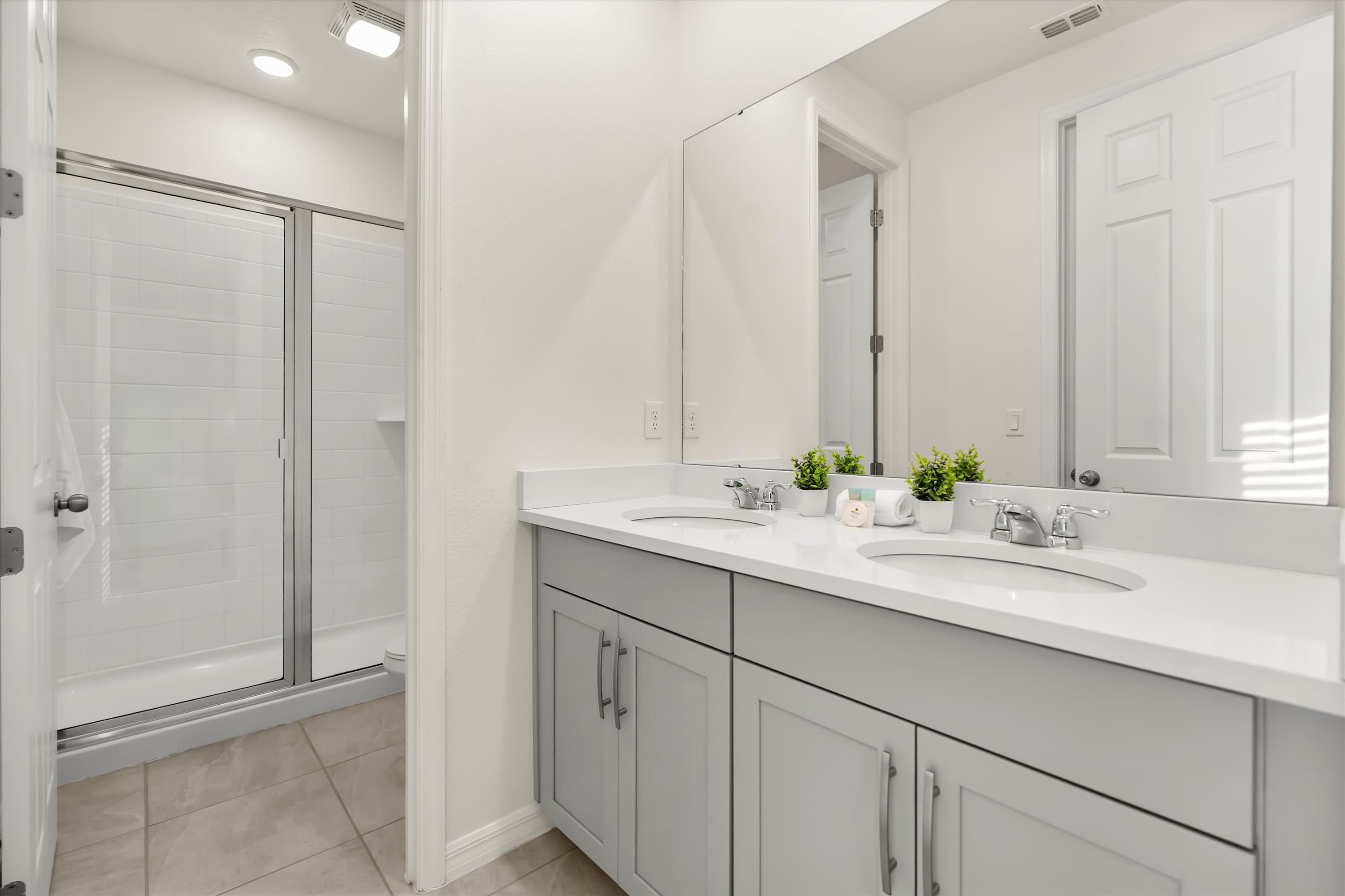 Spacious bathroom featuring walk-in shower, double vanity, and storage for easy mornings.