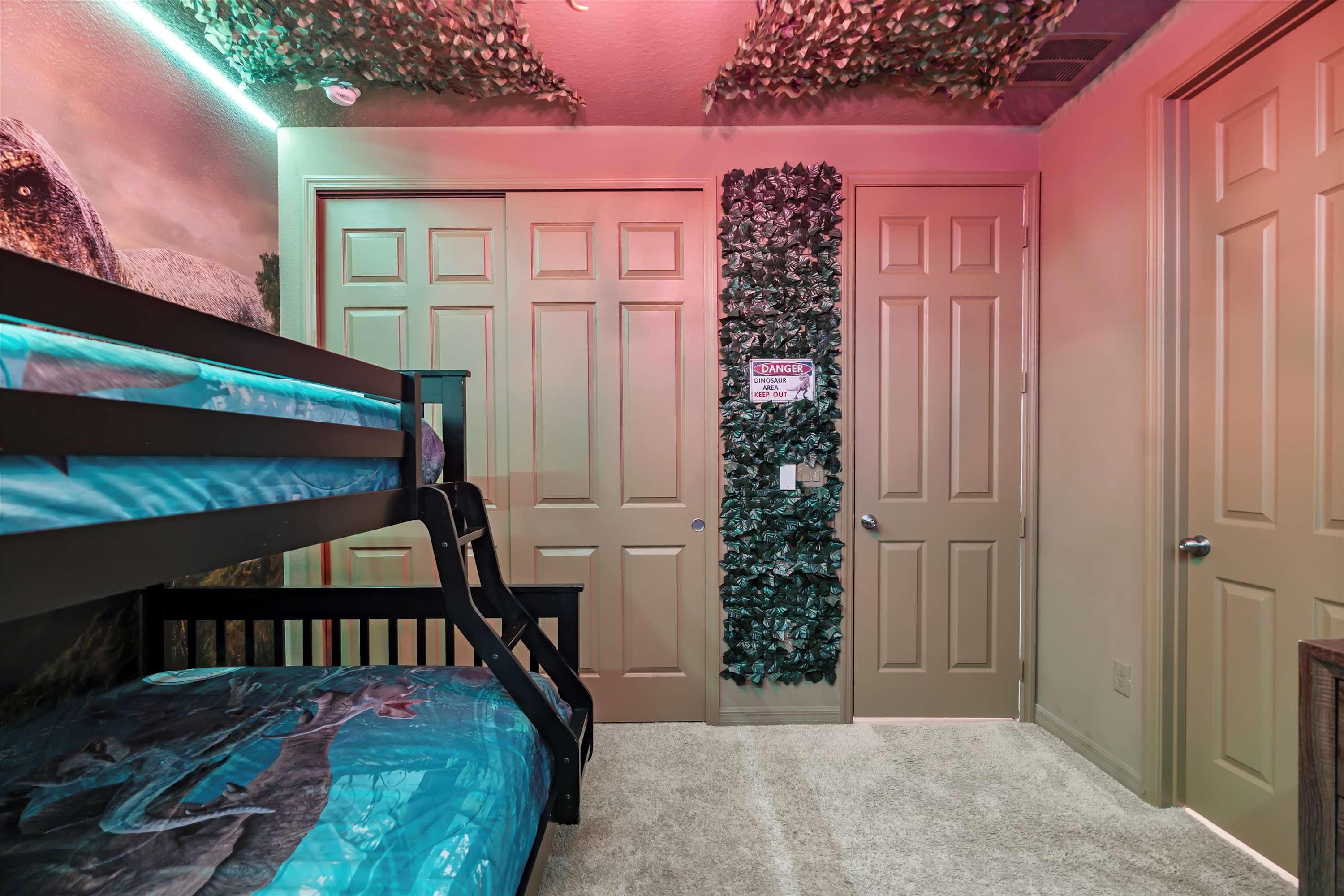 Dinosaur themed bedroom with a bunk bed featuring a double on the bottom and single on top, perfect for kids and families