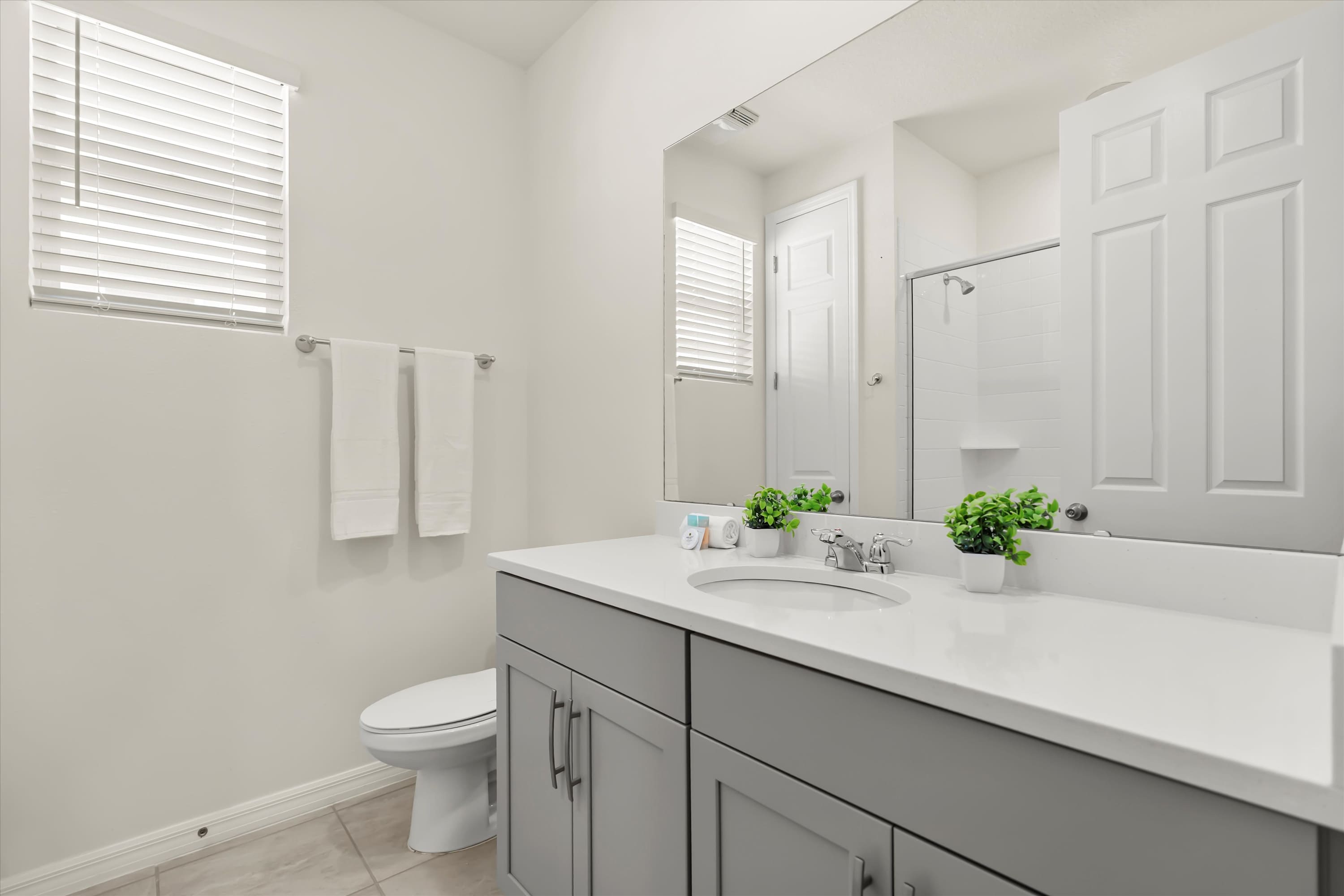 Well-equipped bathroom with mirror, towel, and toilet for guest comfort.