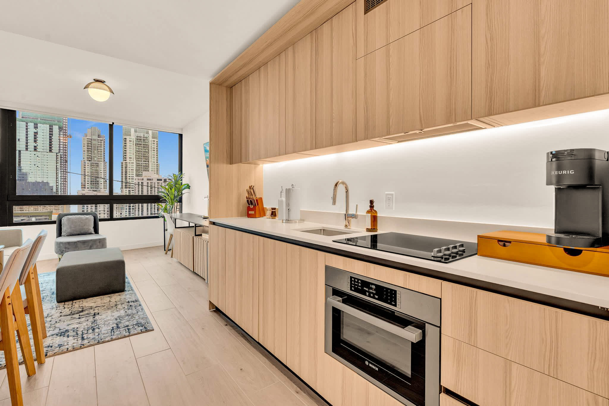 Enjoy cooking with a view in this sleek, modern kitchen featuring top appliances and stunning cityscape vistas.