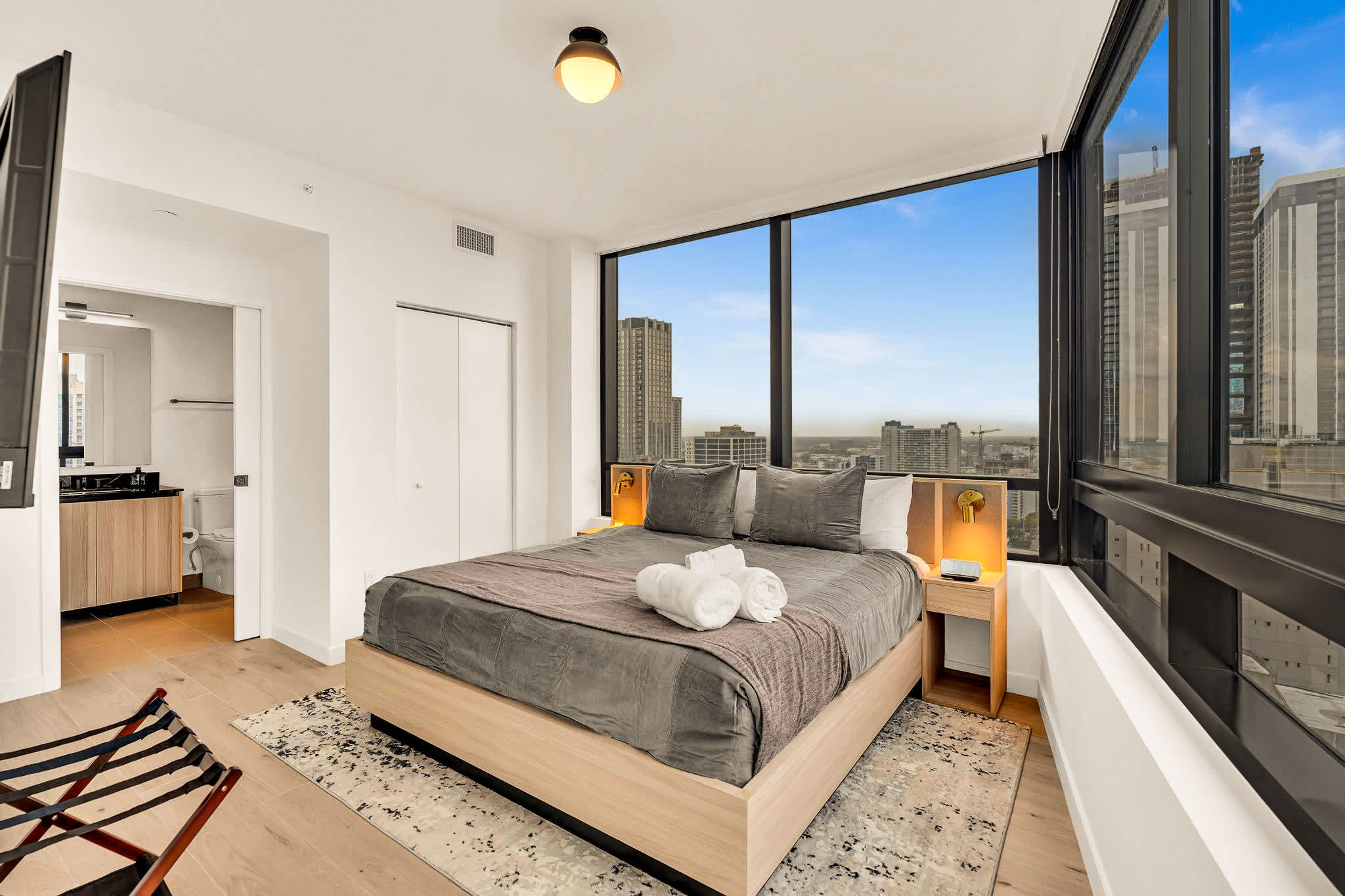 Relax in this stylish bedroom with stunning city views and modern comforts.