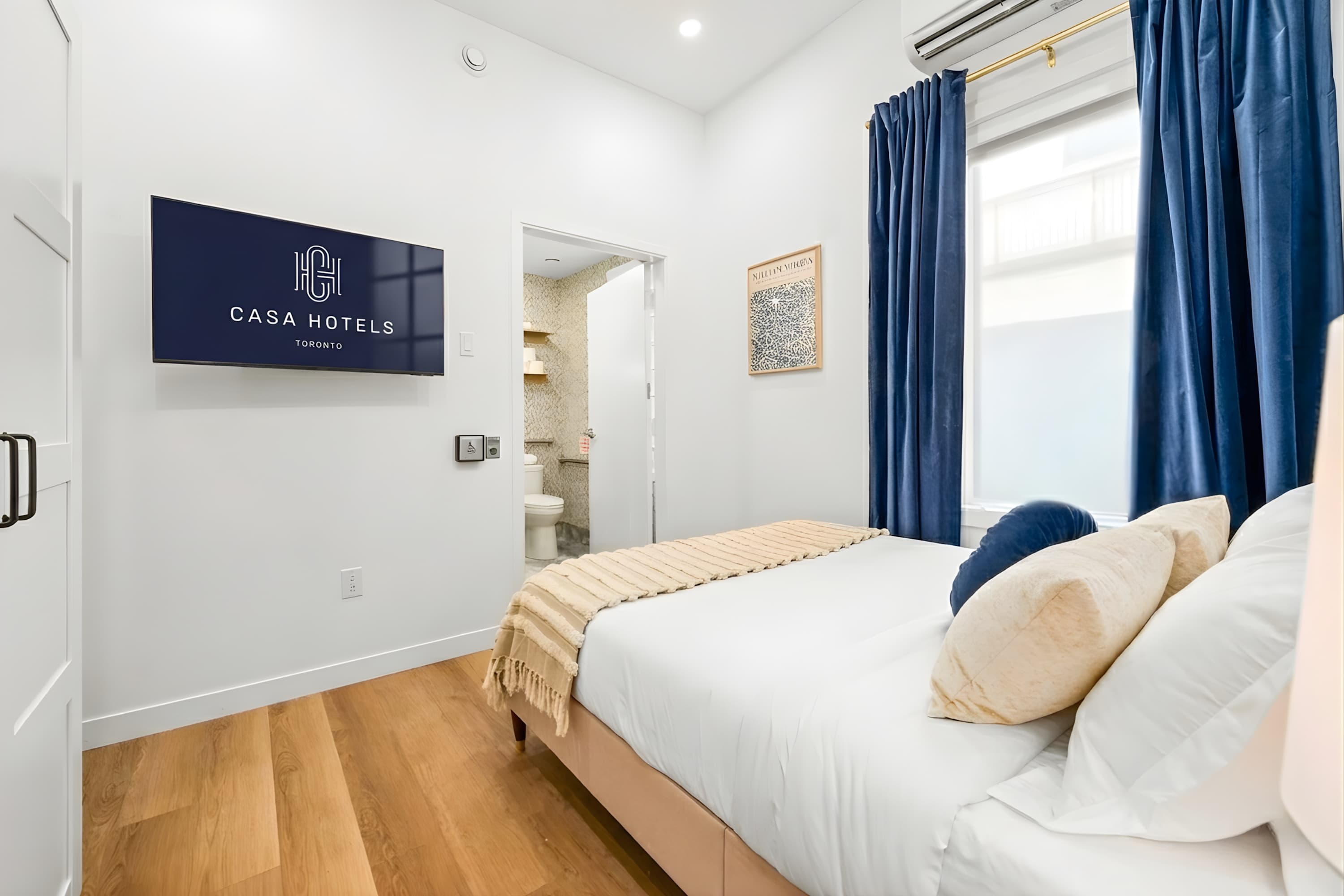 Serene bedroom with a plush queen bed and a smart TV.
