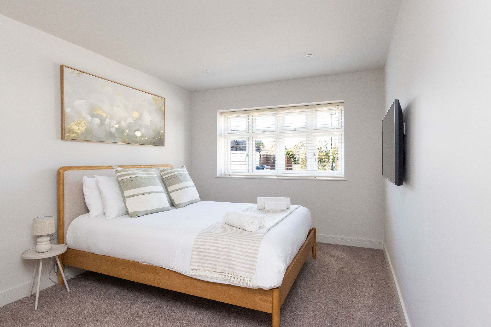 Light, calm bedroom with soft coastal styling and comfortable bedding.