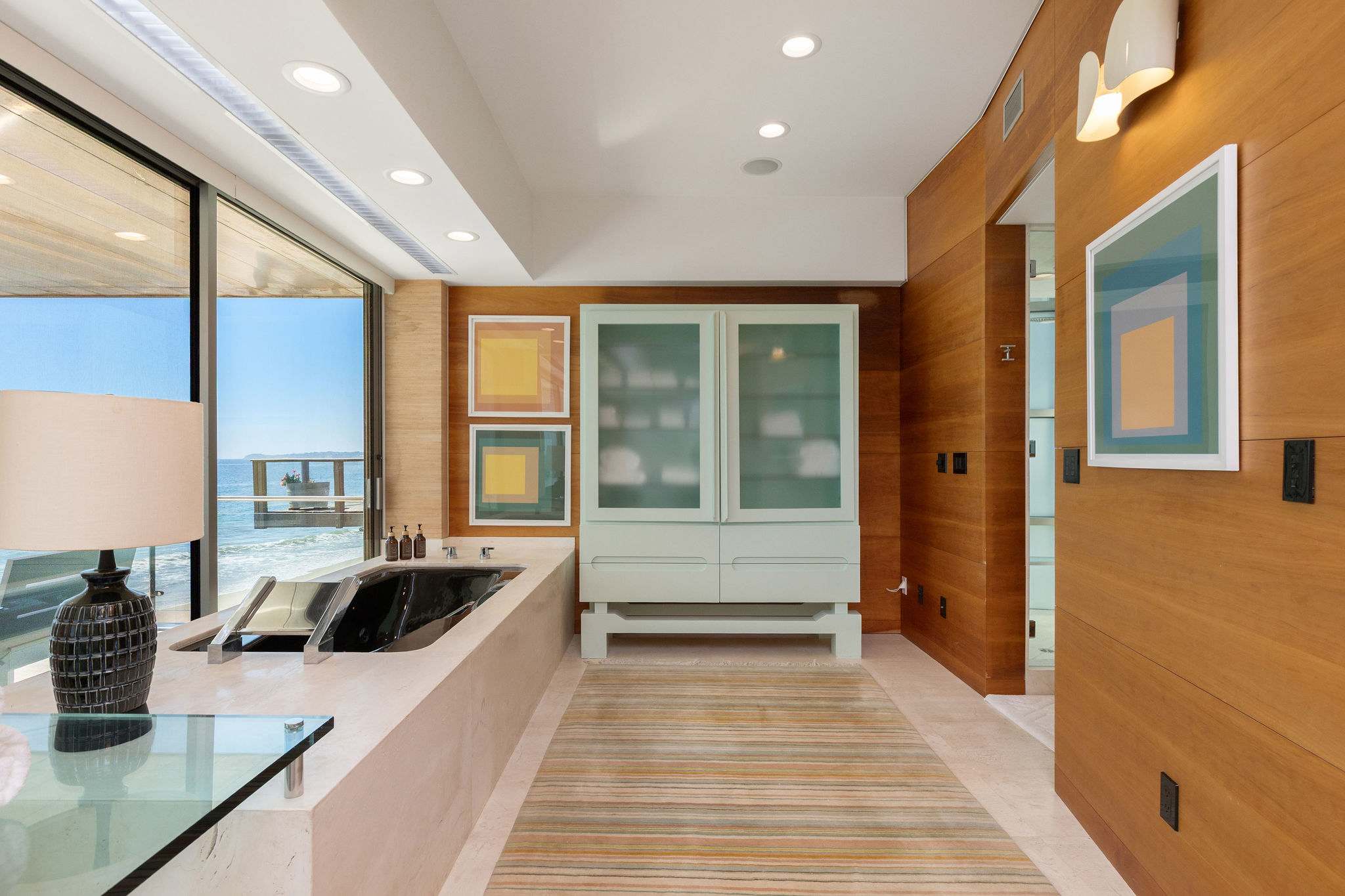 Luxury Malibu bath suite with custom wood paneling and oceanfront outlook.