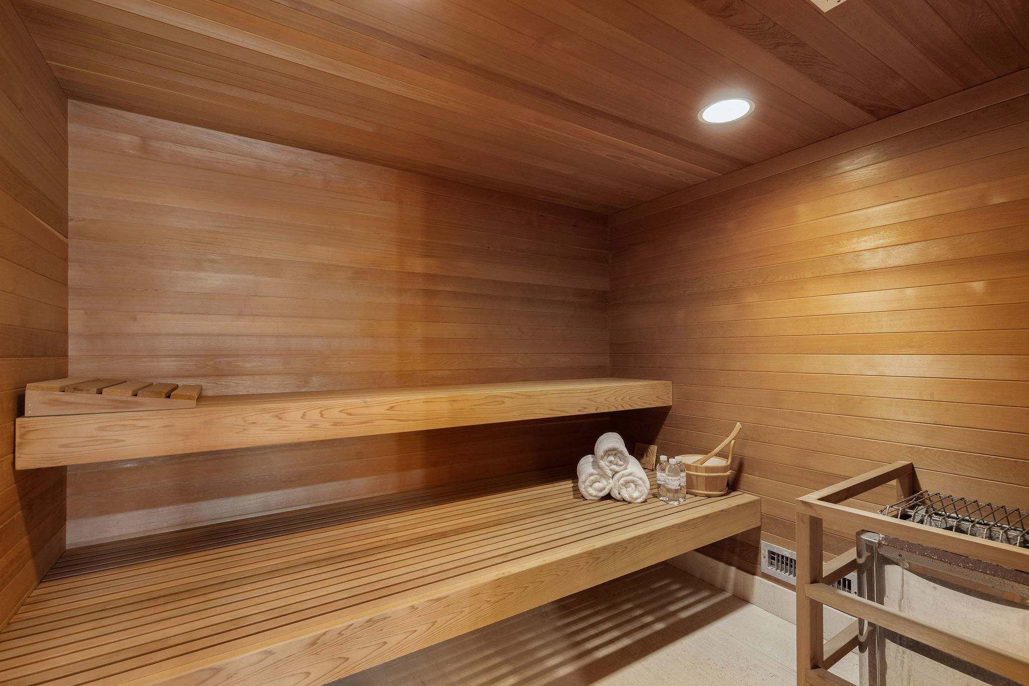 Private wellness amenities including gym, sauna, steam, and spa overlooking the coast.