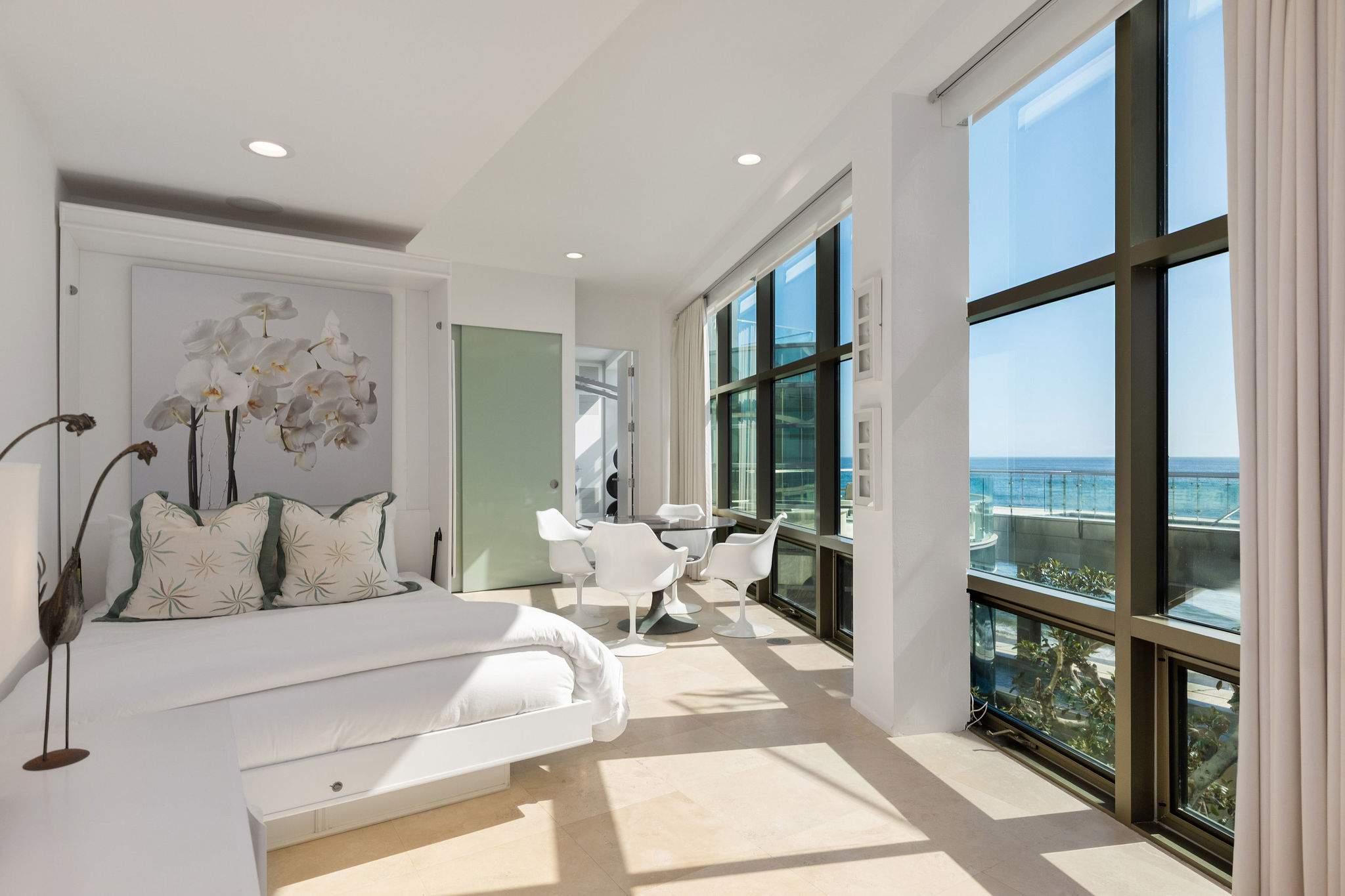Oceanview bedroom framed by expansive Malibu glass walls.