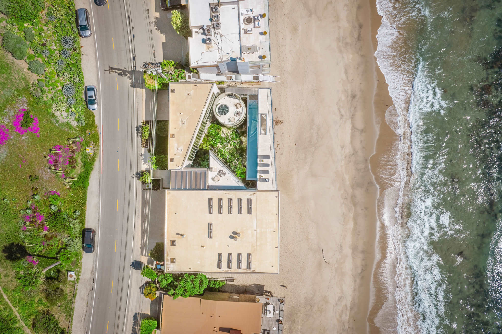 Aerial view of Malibu beachfront homes and Pacific waves.