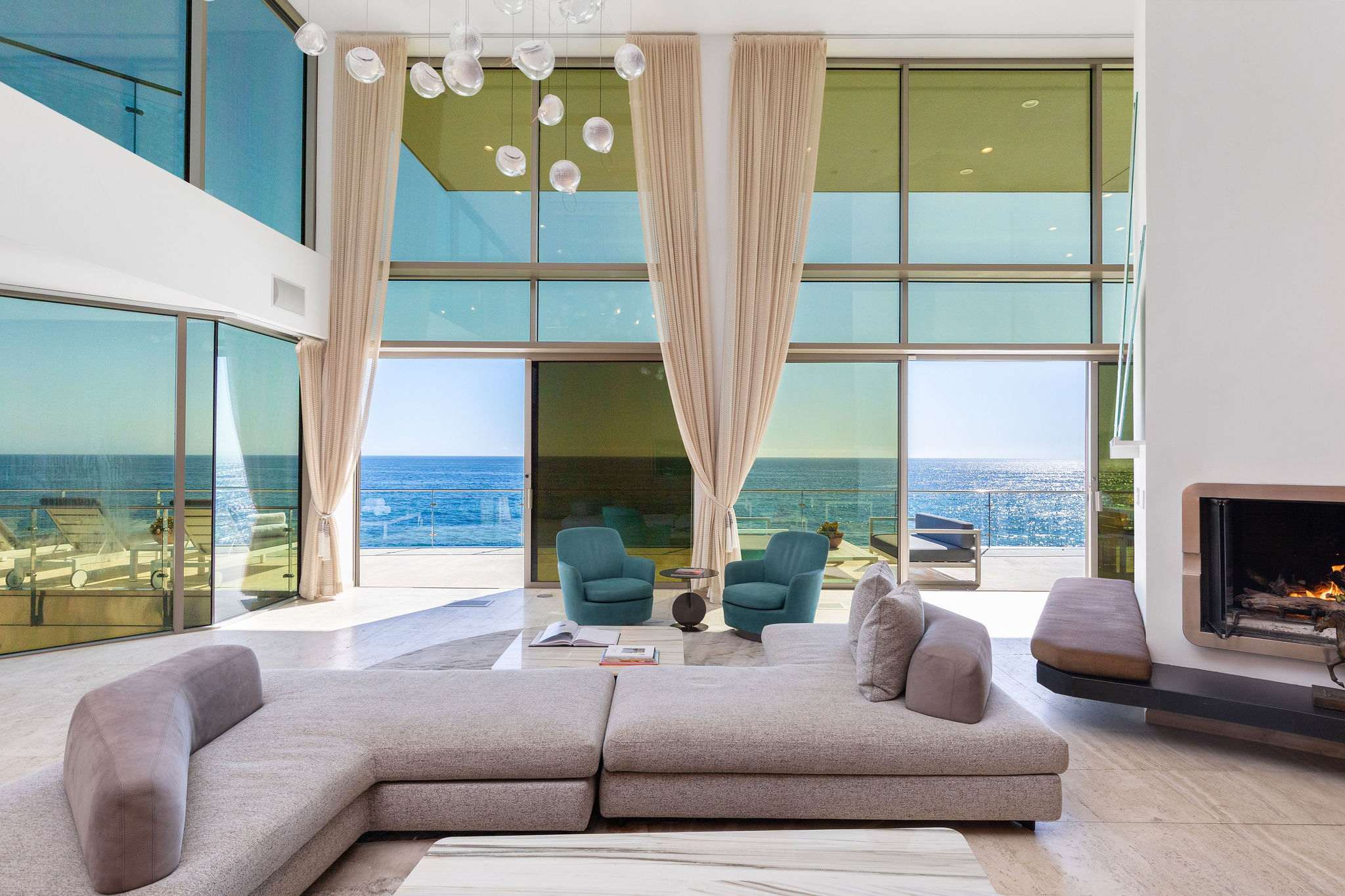 Grand double-height living room overlooking the Pacific.