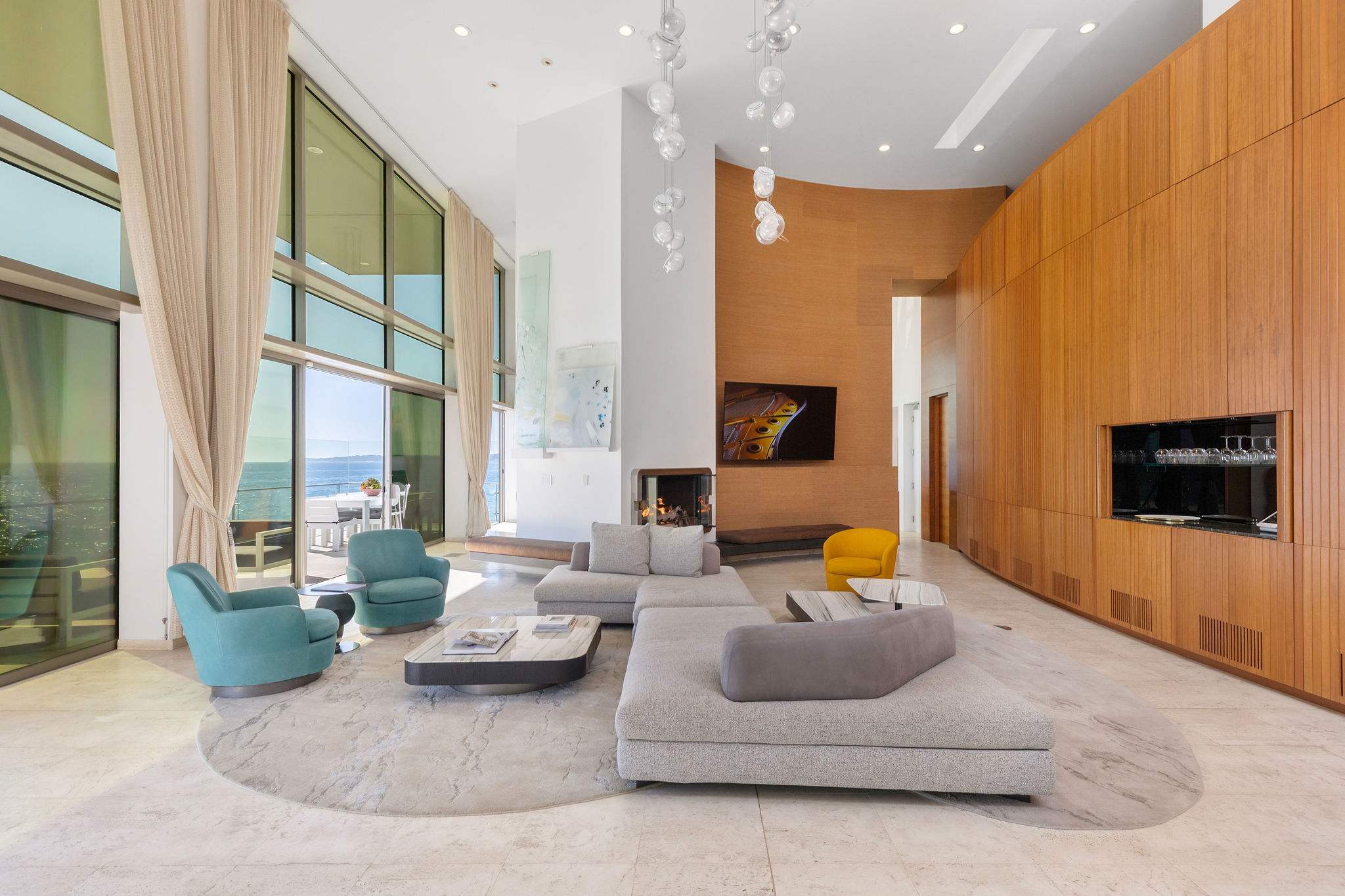 Modern Malibu living area with custom wood paneling and oceanfront outlook.