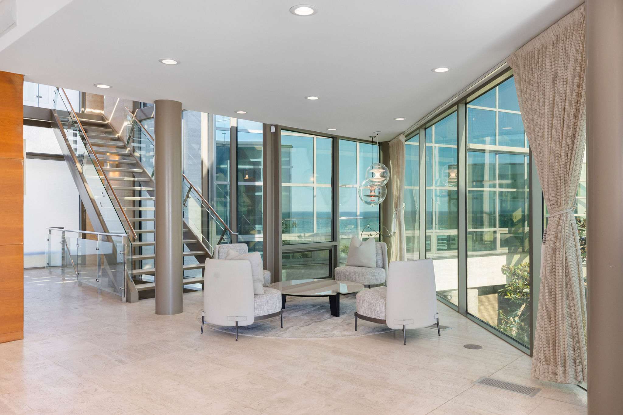 Oceanview dining area framed by floor-to-ceiling glass in Malibu.