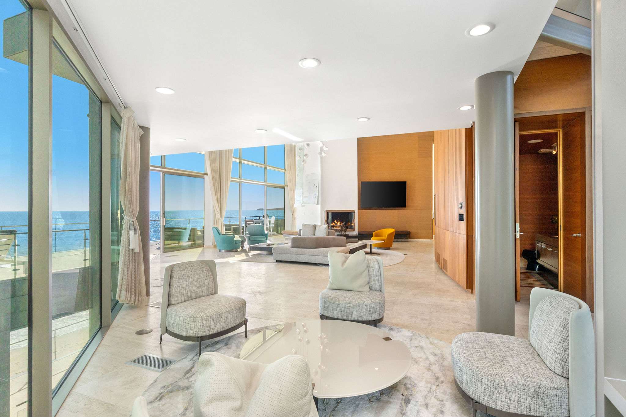 Ocean-facing lounge framed by floor-to-ceiling glass and Malibu views.