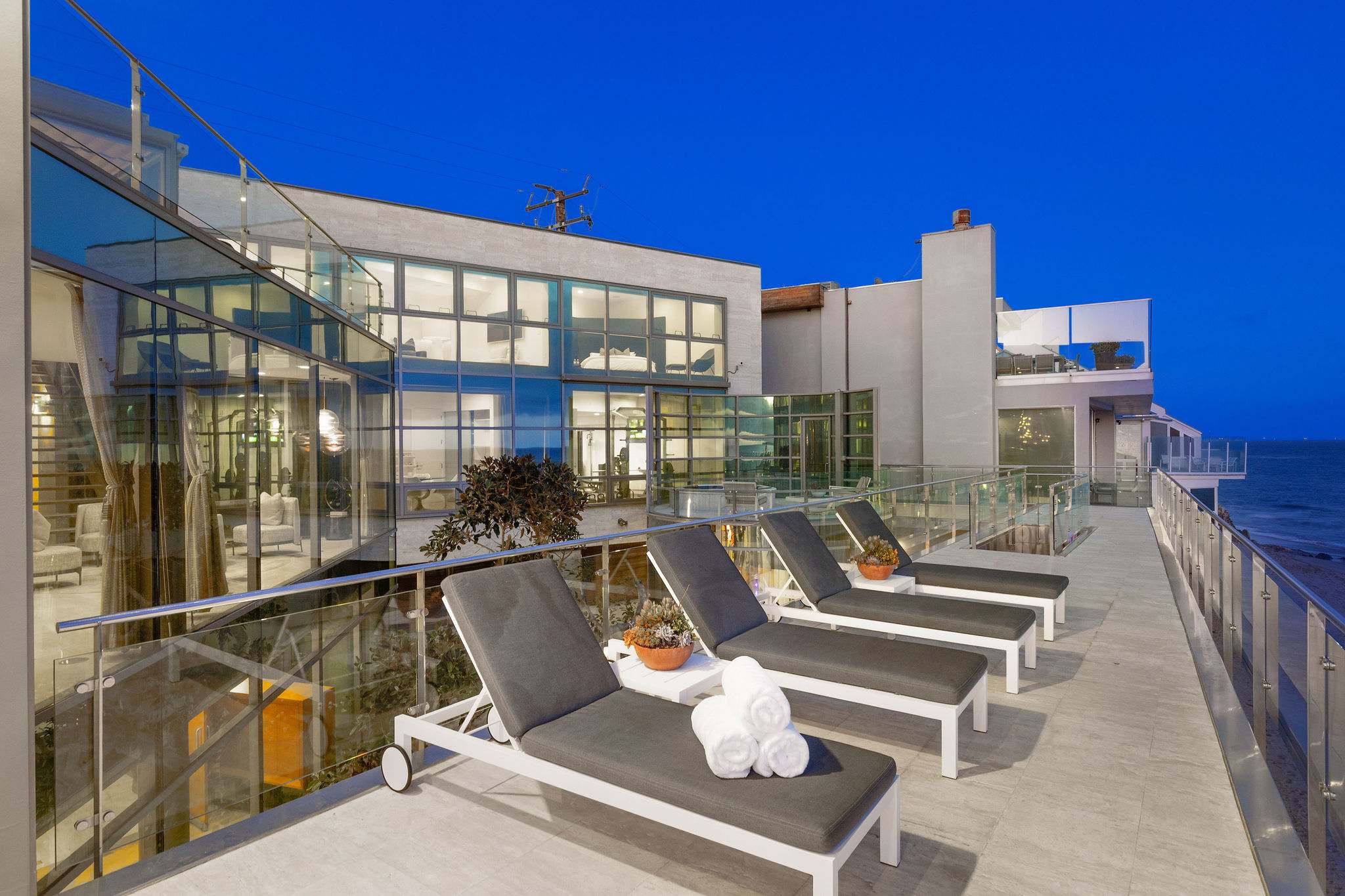 Grand Malibu oceanfront living room with double-height ceilings and dramatic architectural lighting.