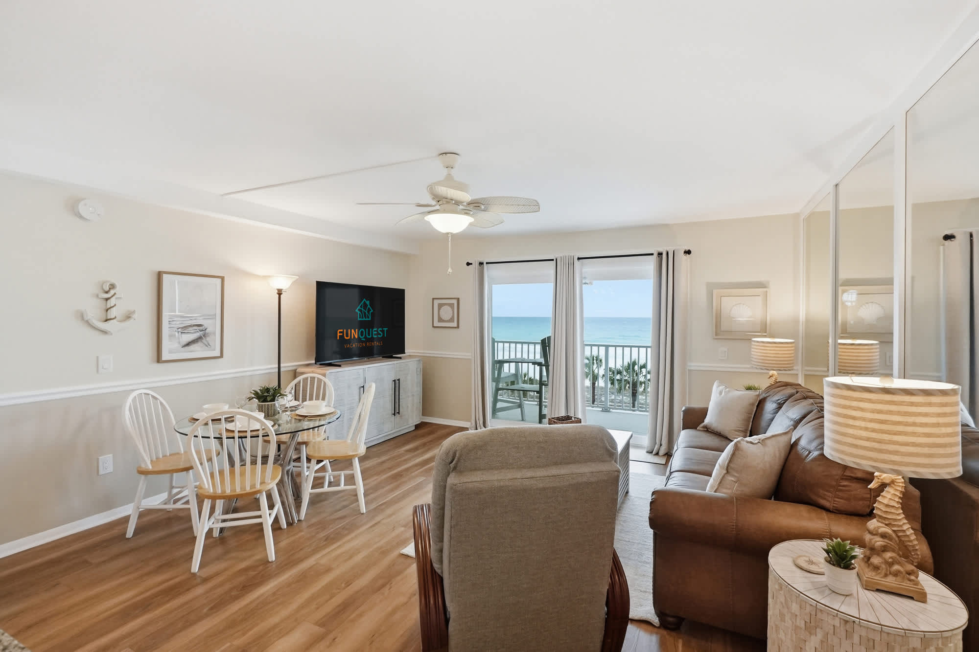 The Summit 419 – Living room with couch, dining area, large windows, and ocean view from the balcony.