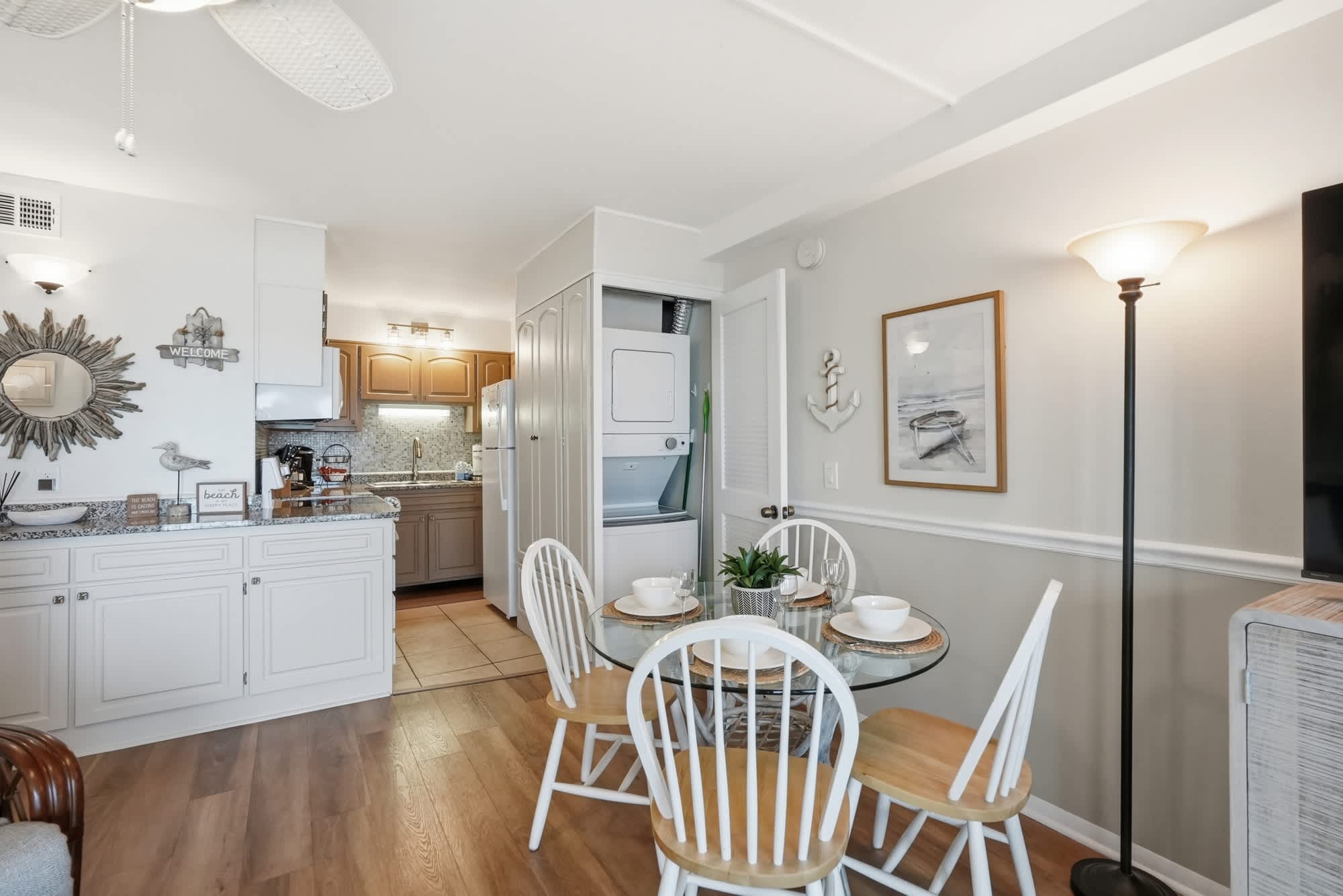 The Summit 419 – Cozy vacation rental kitchen and dining area with white chairs and table, featuring a washer and modern appliances.