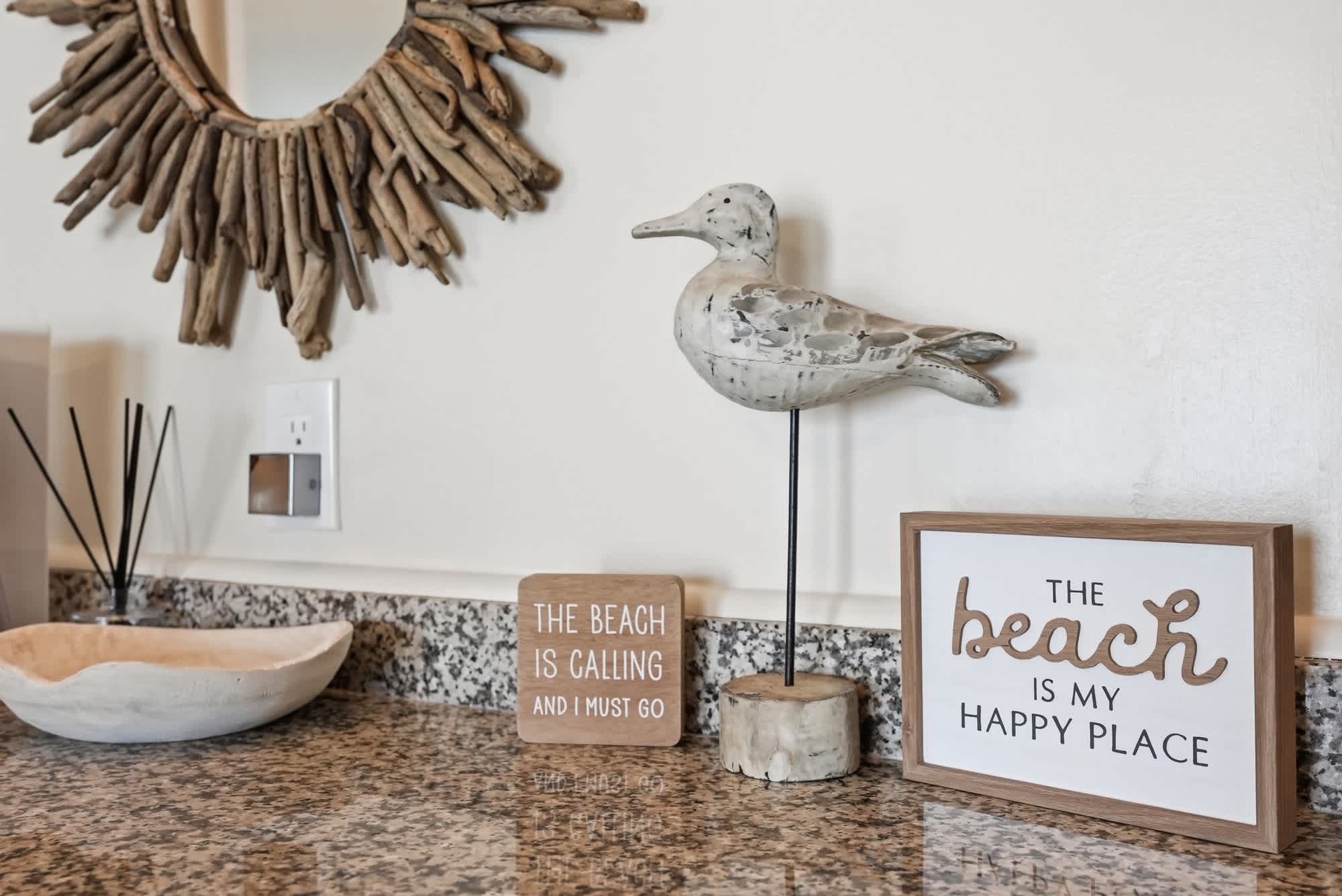 The Summit 419 – Decorative items on a granite countertop, including a bird figurine and wooden signs.