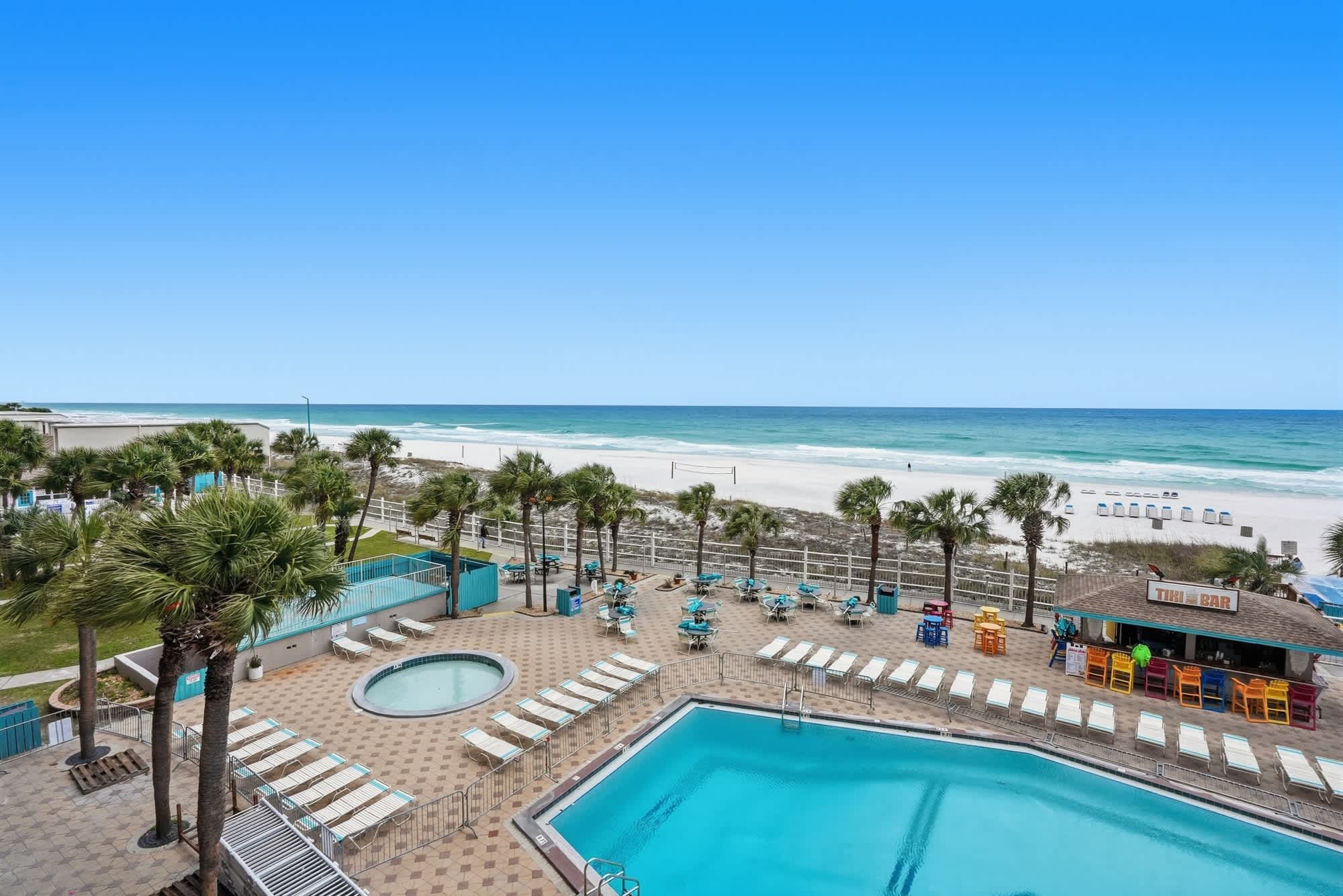 The Summit 419 – Pool area with lounge chairs, hot tub, bar, and ocean view.