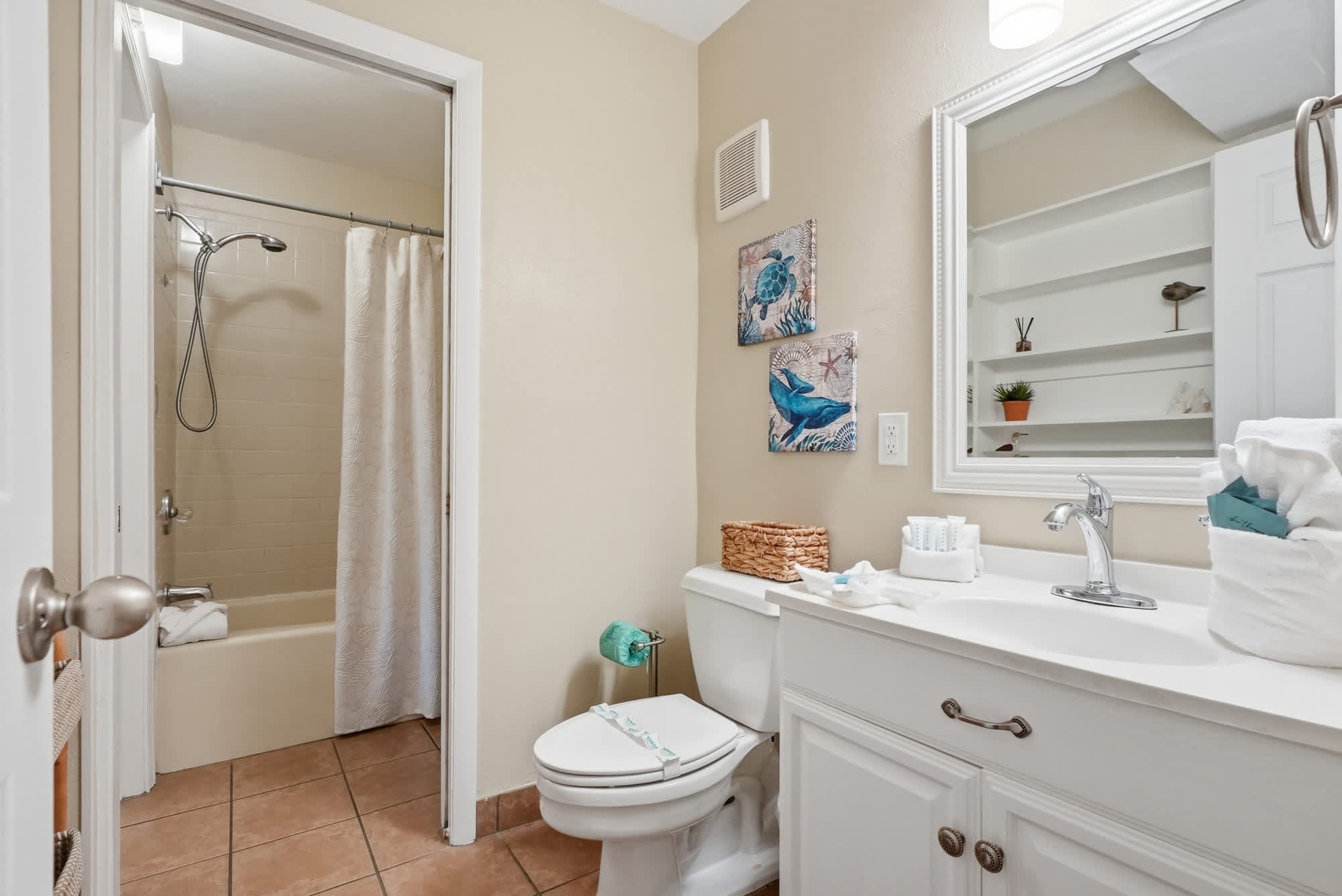 The Summit 419 – Bathroom with shower, toilet, sink, decorative art, and storage shelf.