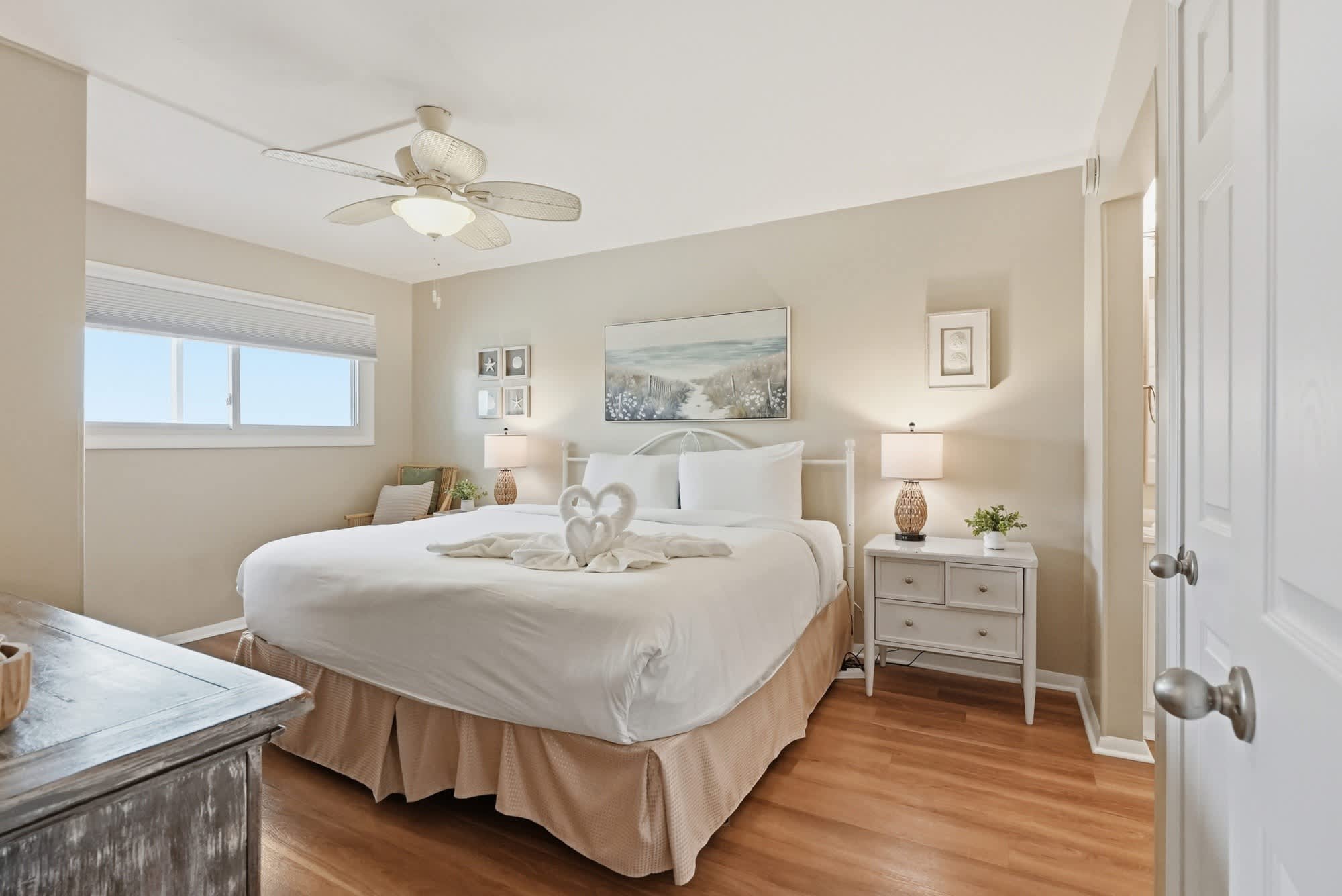The Summit 419 – Cozy bedroom with a queen bed, ceiling fan, and art. Natural light from window.