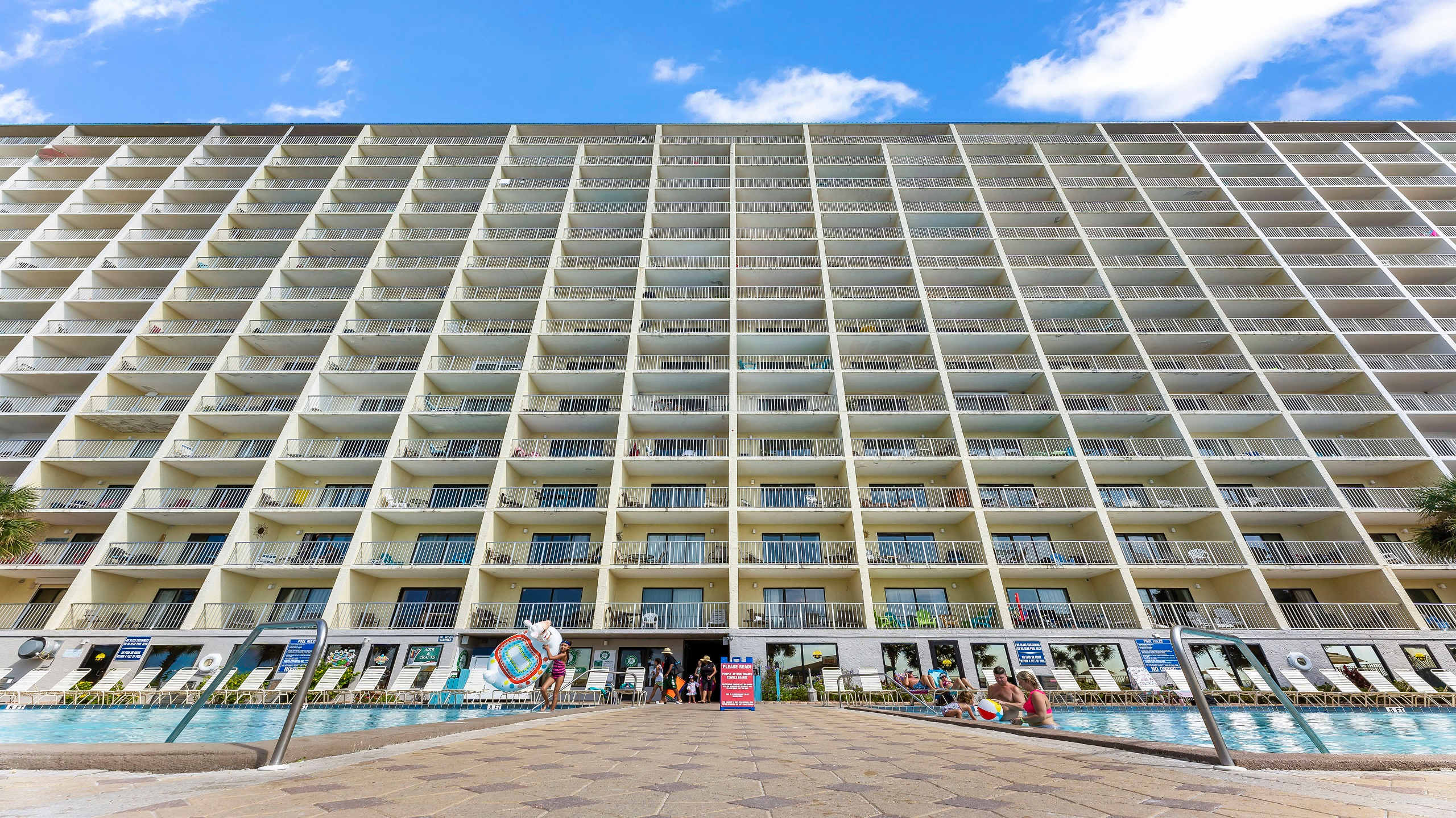 The Summit 419 – Large vacation rental building with multiple balconies and a pool area in the foreground.