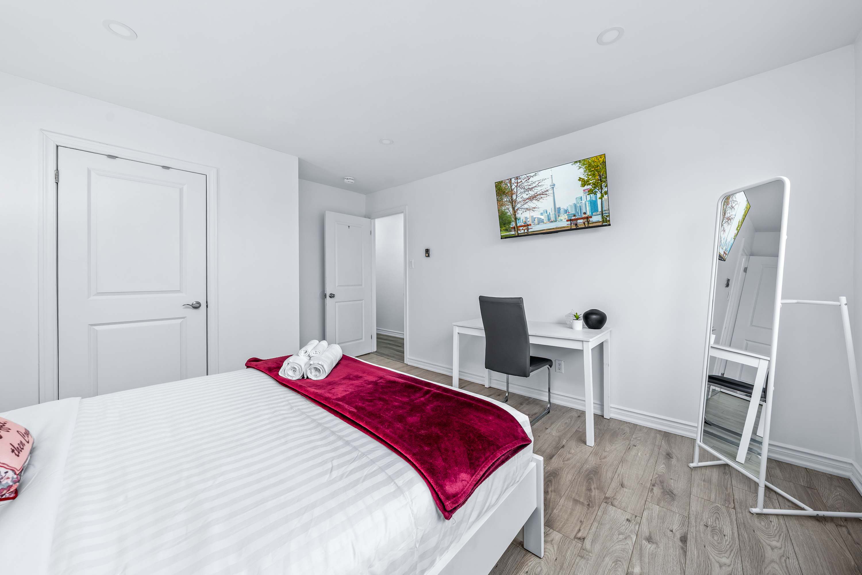 Bedroom with workspace and full-length mirror.