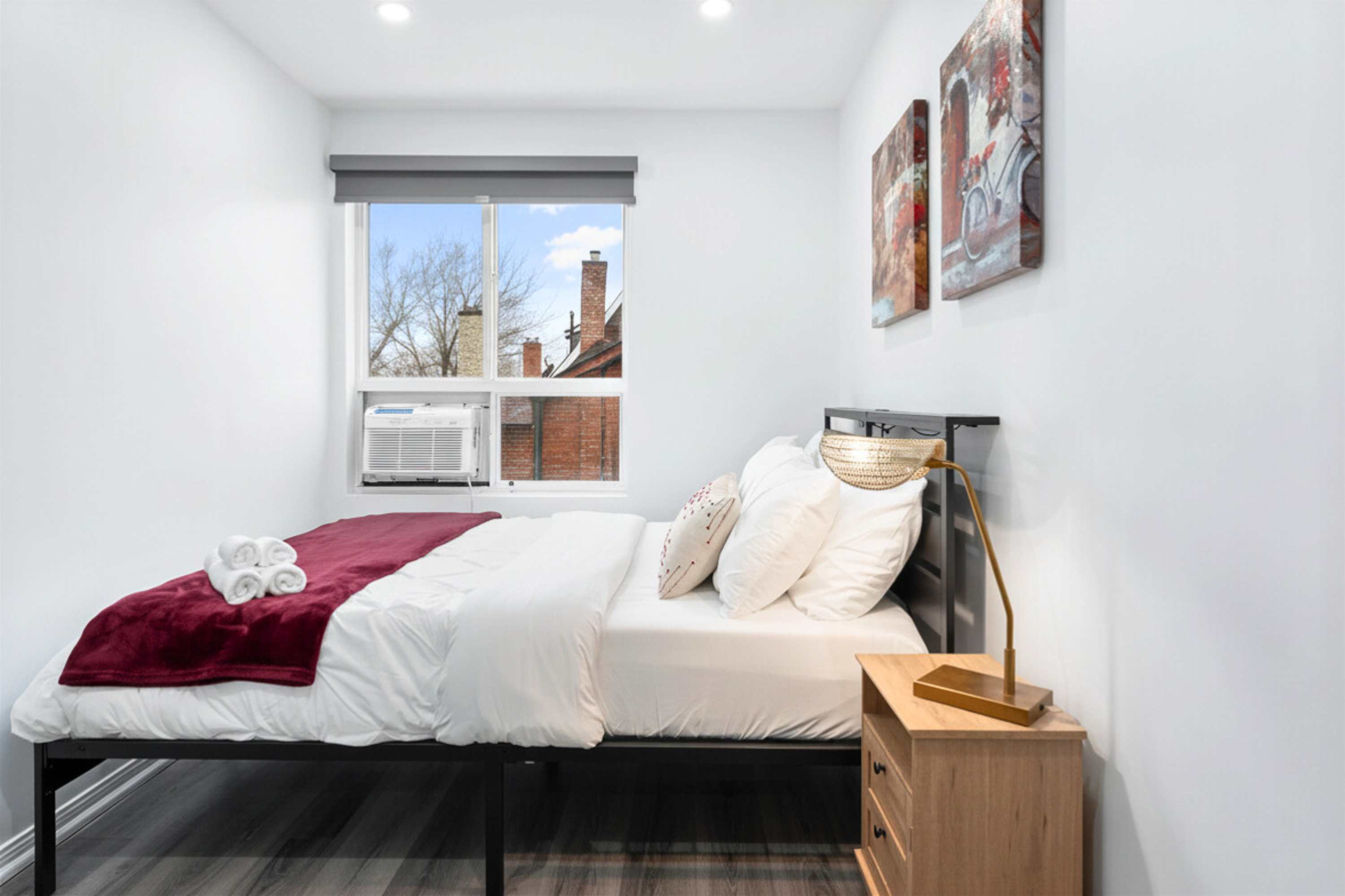 Queen bedroom with silk covers, fresh towels, smart TV, and a cozy lamp for relaxing nights
