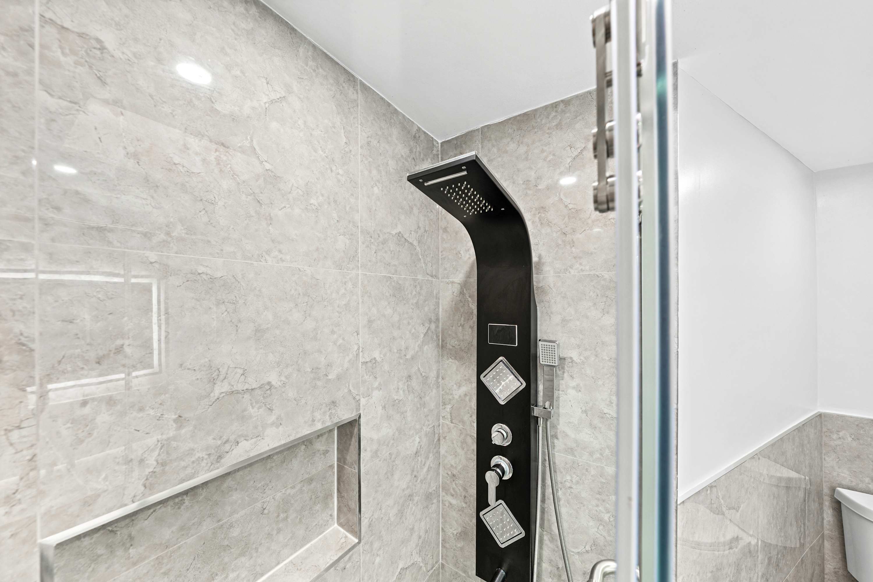 A clean vanity room and a versatile walk-in shower.